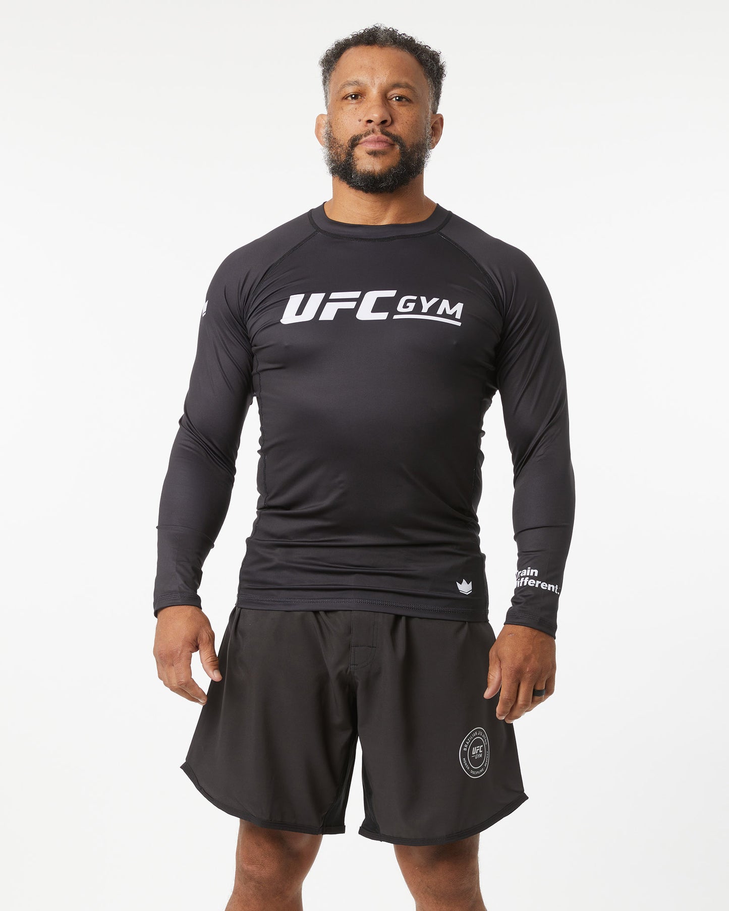 Person wearing a black UFC Gym shirt and shorts on a white background