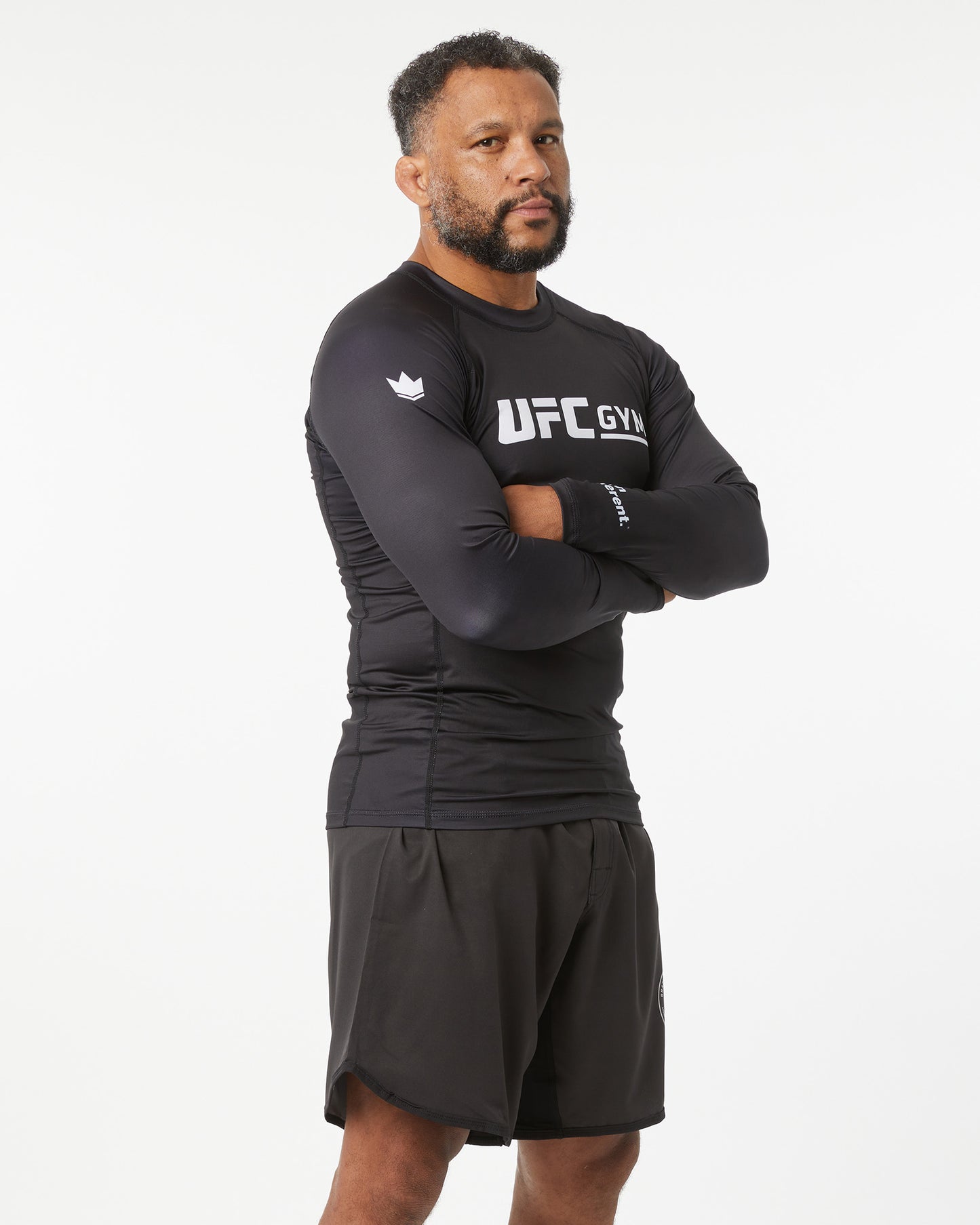 Man wearing a black UFC Gym outfit on a white background in a slightly left-facing angle