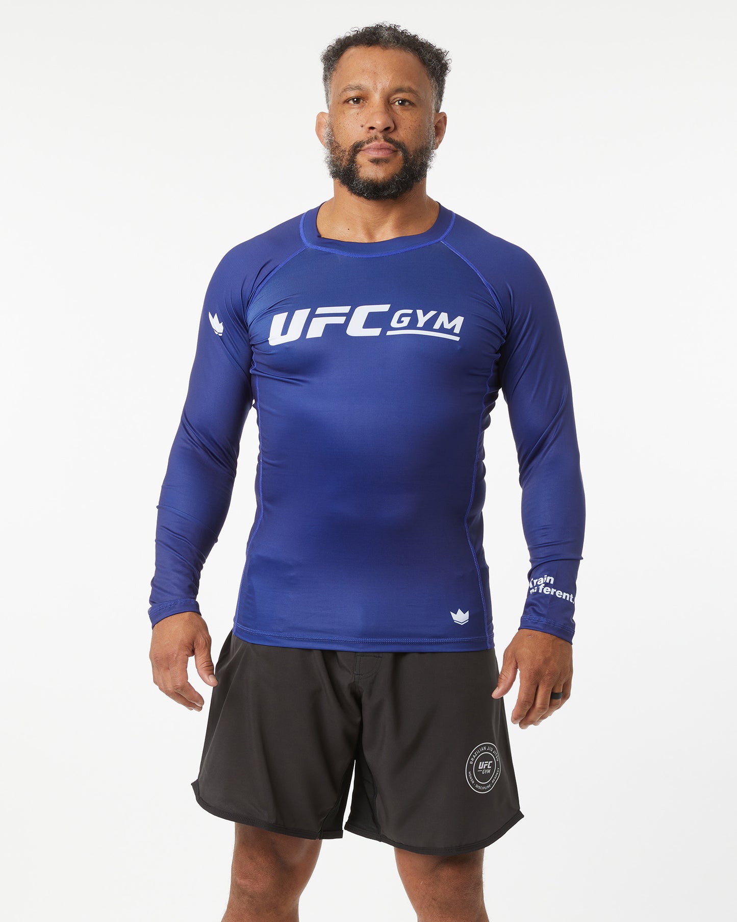 Person wearing a blue UFC Gym long-sleeve shirt on a white background facing forward