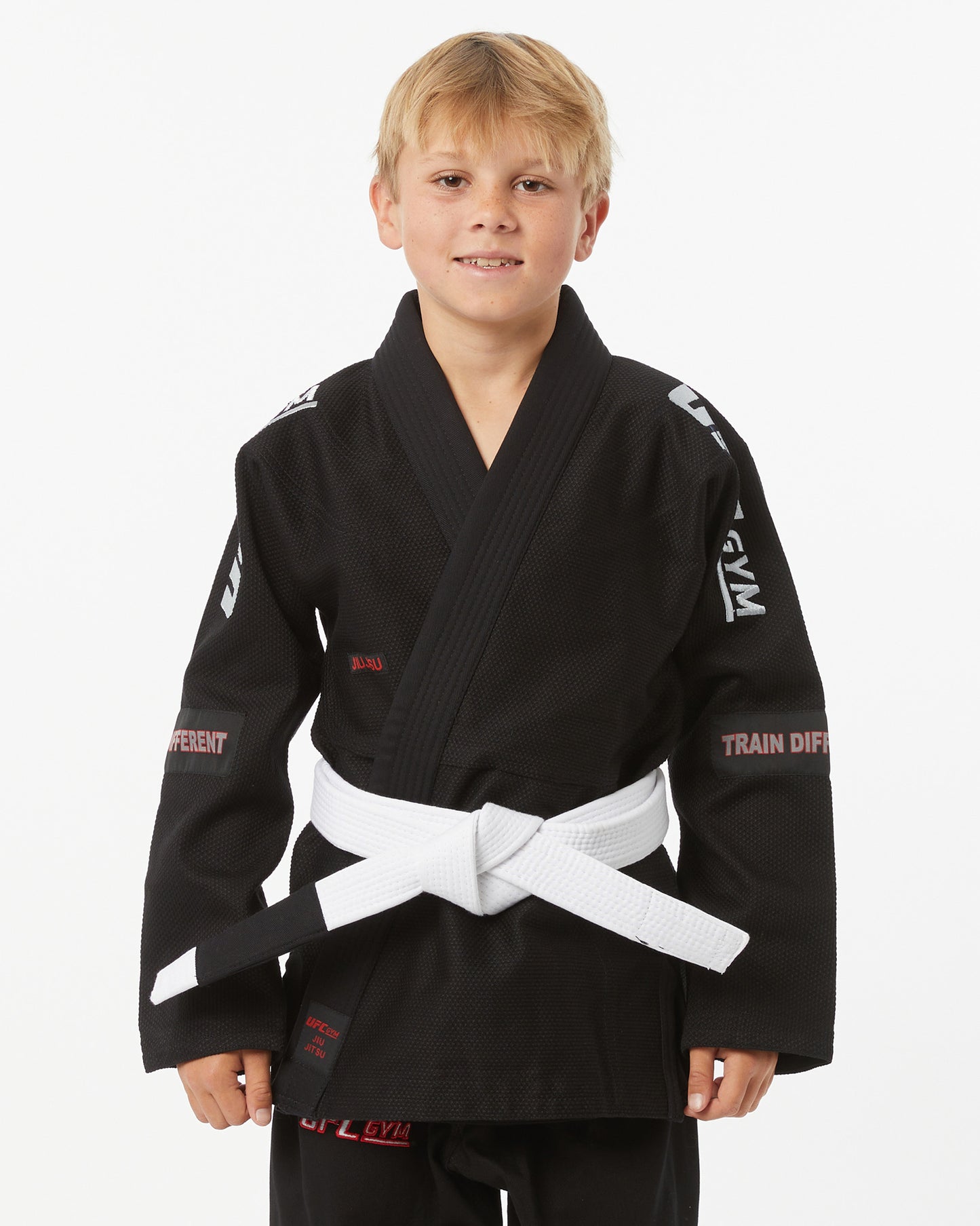 Child wearing a black UFC Gym gi with a white belt on a white background facing forward