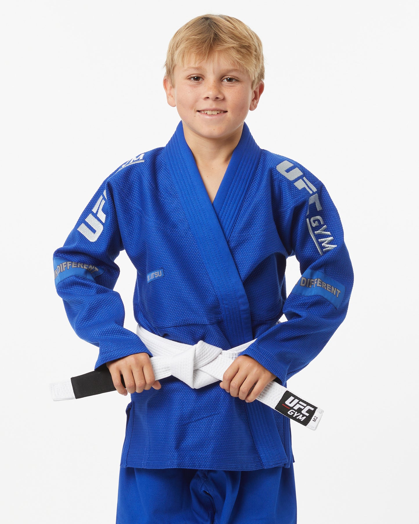 Child wearing a blue UFC Gym gi with a white belt on a white background facing forward