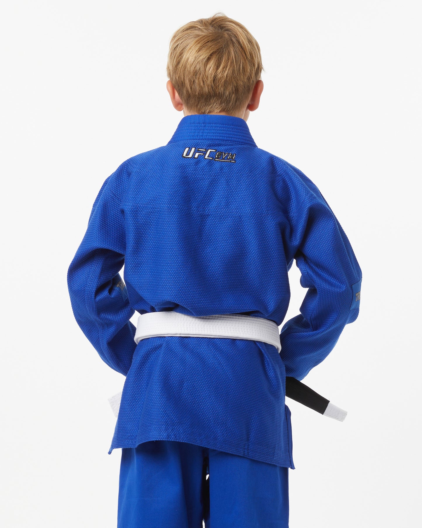 Child wearing a blue UFC uniform on a white background facing backward