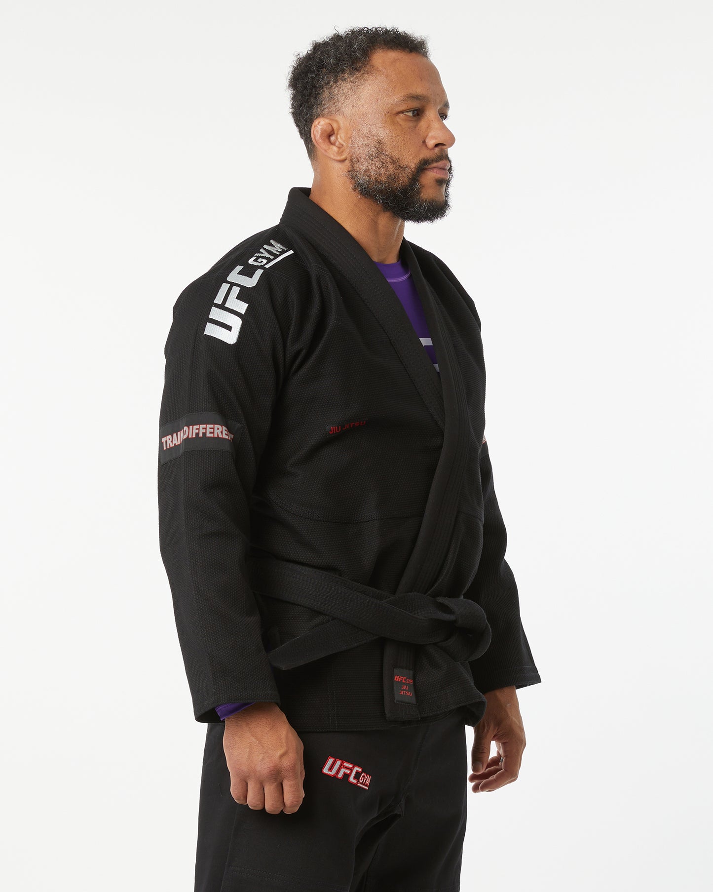 Person wearing a black UFC branded gi on a white background facing right