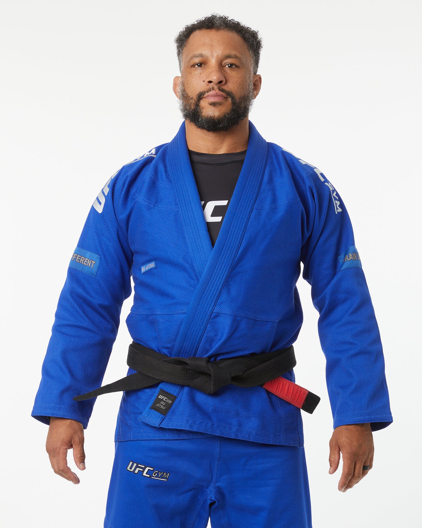 Man wearing a blue UFC gym gi with a black belt on a white background facing forward, arms down