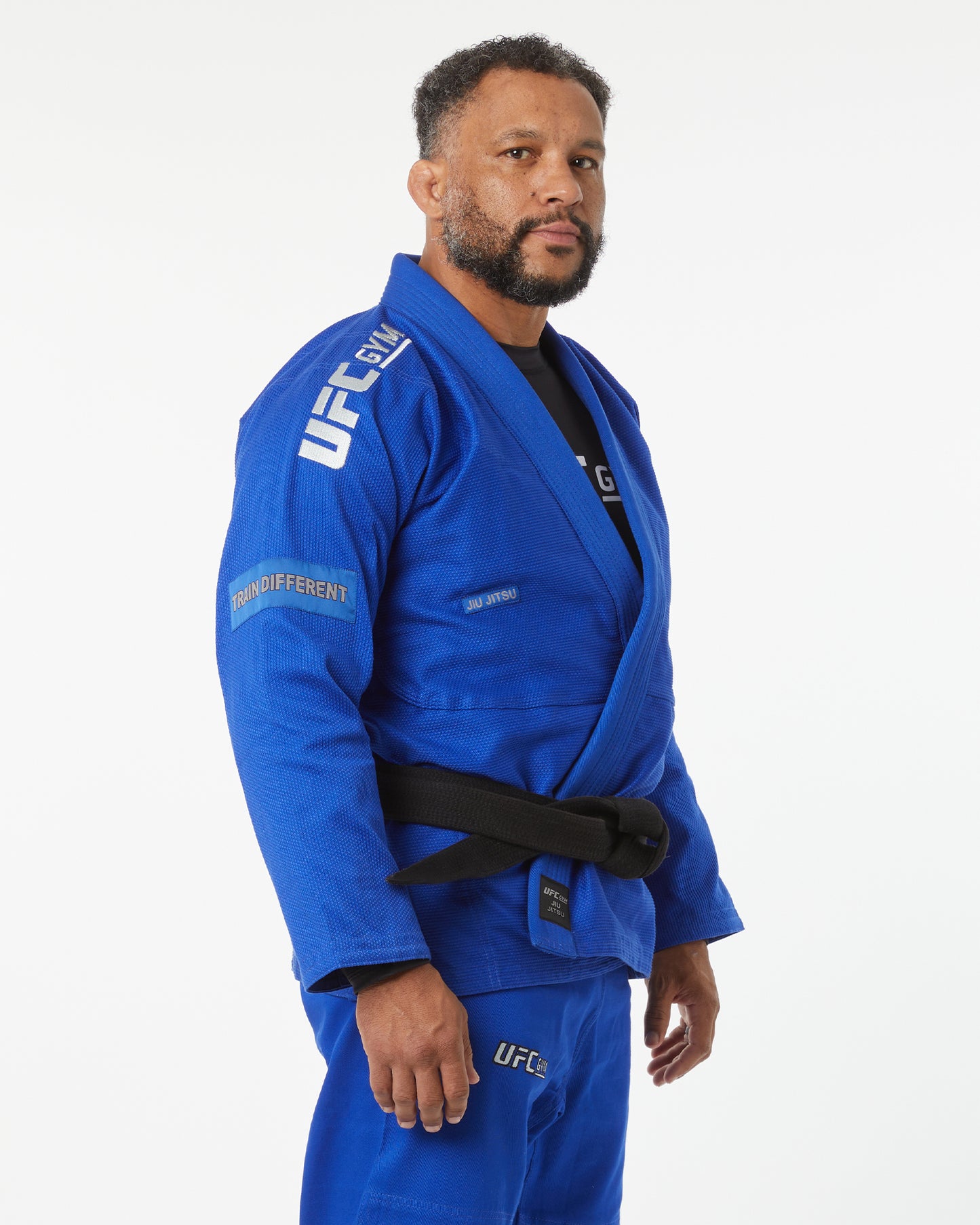 Man wearing a blue UFC gi on a white background right-facing looking forward