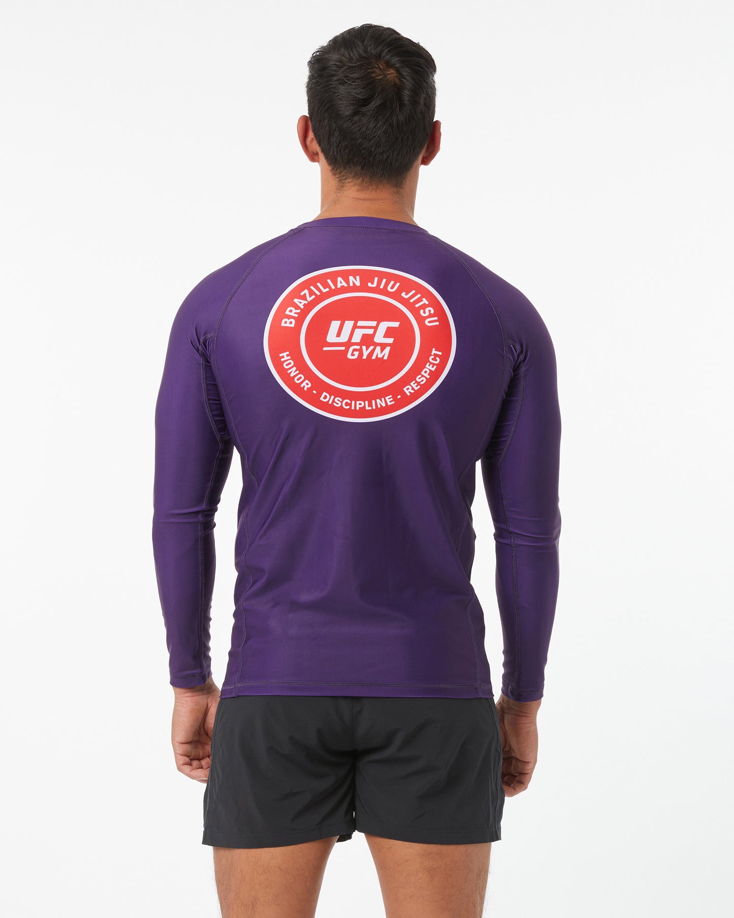 Person wearing a purple UFC Gym long-sleeve shirt with a red logo on the back.