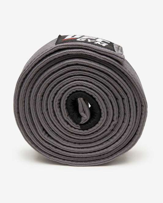 Gray UFC Gym belt on a white background on it's side