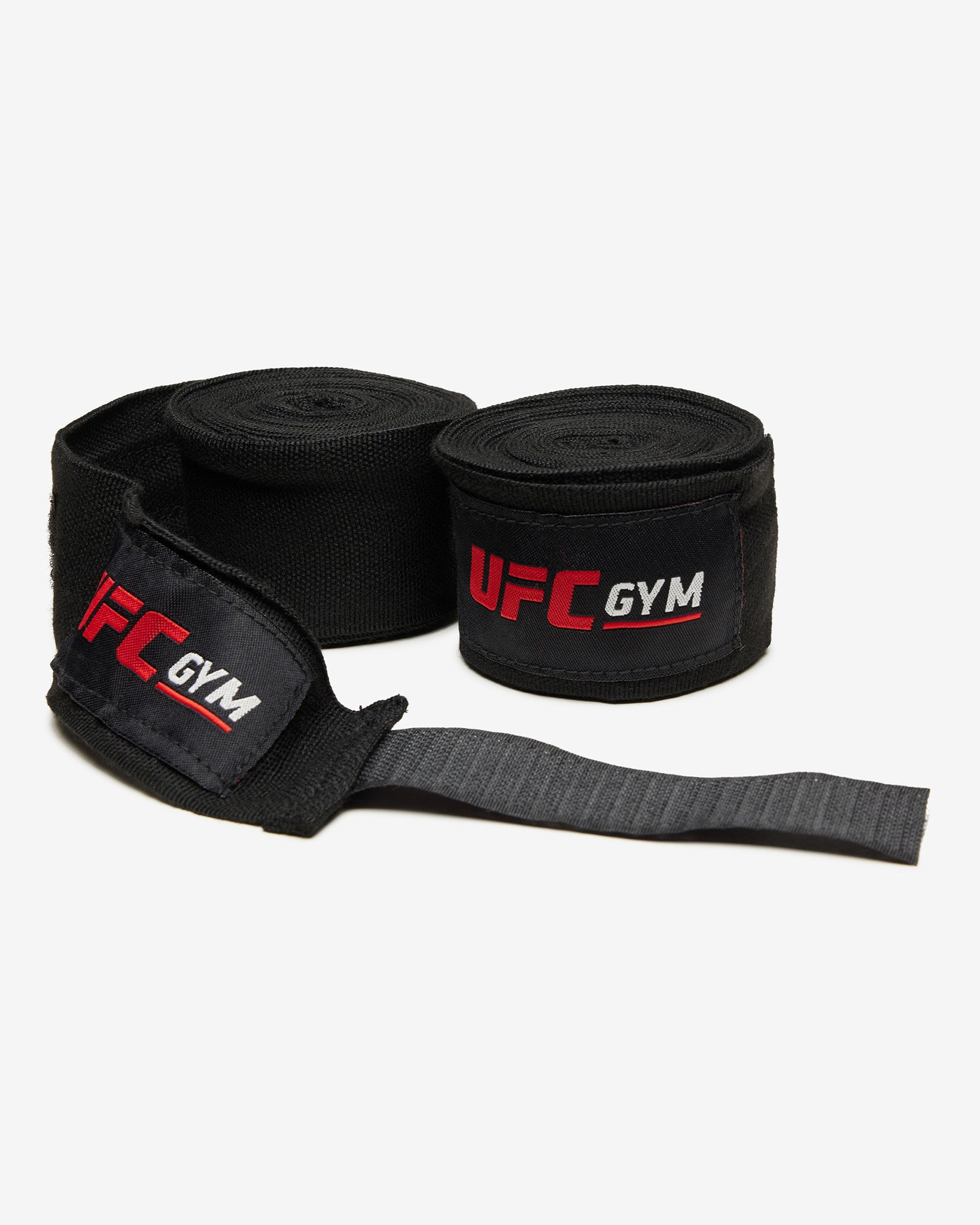 Two black TD 180 Hand Wraps by UFC Gym with padded wrist loops and long straps, inspired by MMA wraps, are displayed side by side on a white background—ideal for injury prevention during intense training.