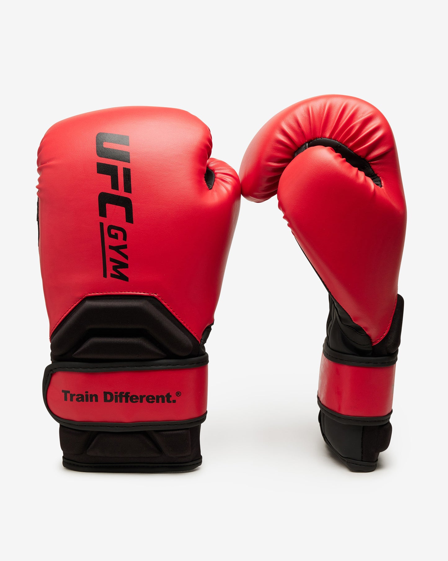 A pair of bright red UFC Gym TD Adult Boxing Gloves, featuring black accents and Train Different. on the wrist strap, are shown—one palm down, one upright—against a plain white background, designed for superior protection and performance.