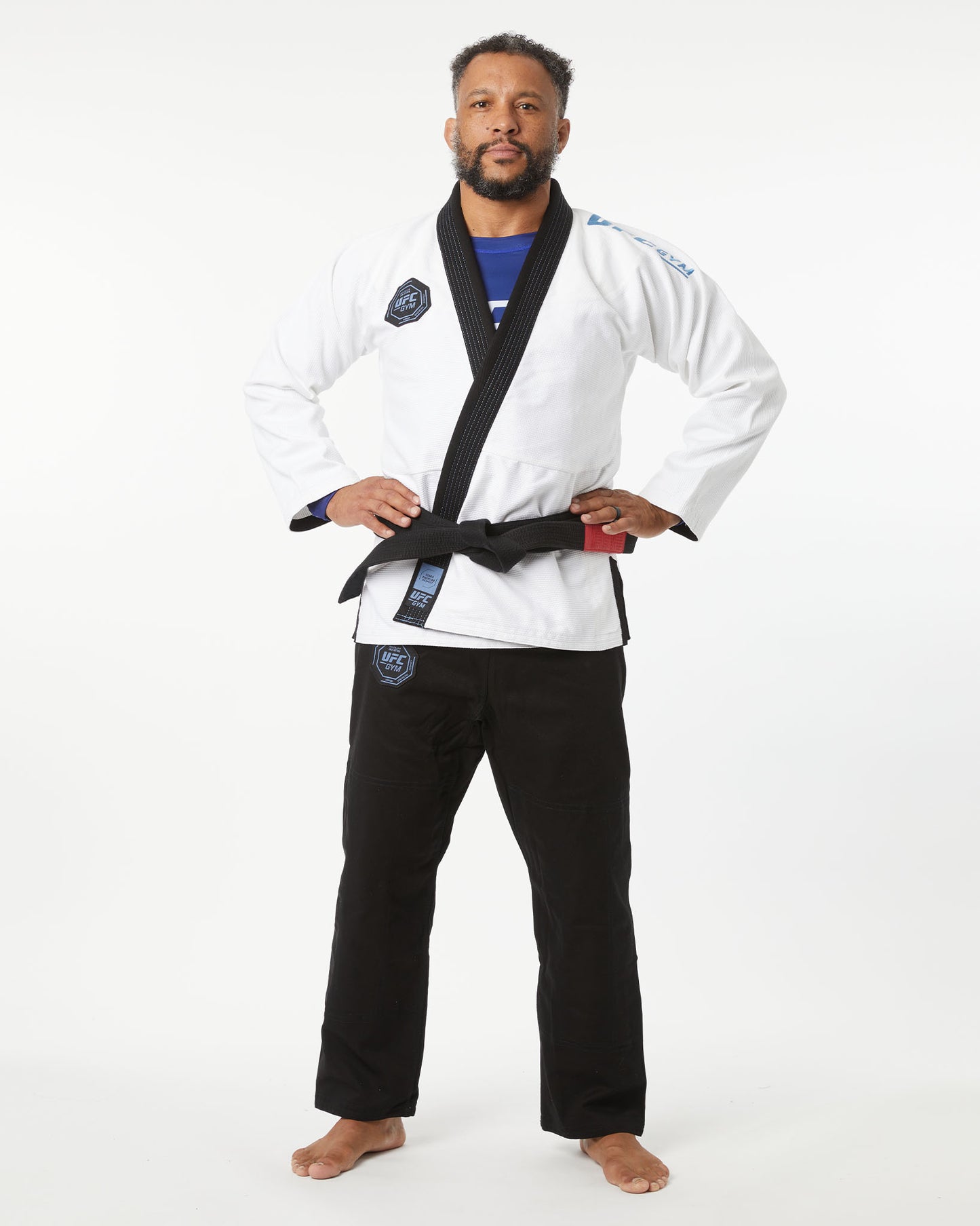 Man wearing a white martial arts uniform with a black belt on a white background
