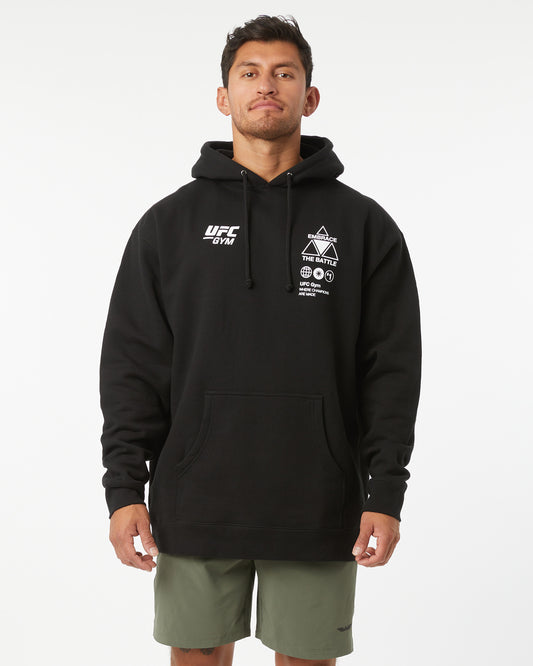 Man wearing a black UFC hoodie on a white background facing forward