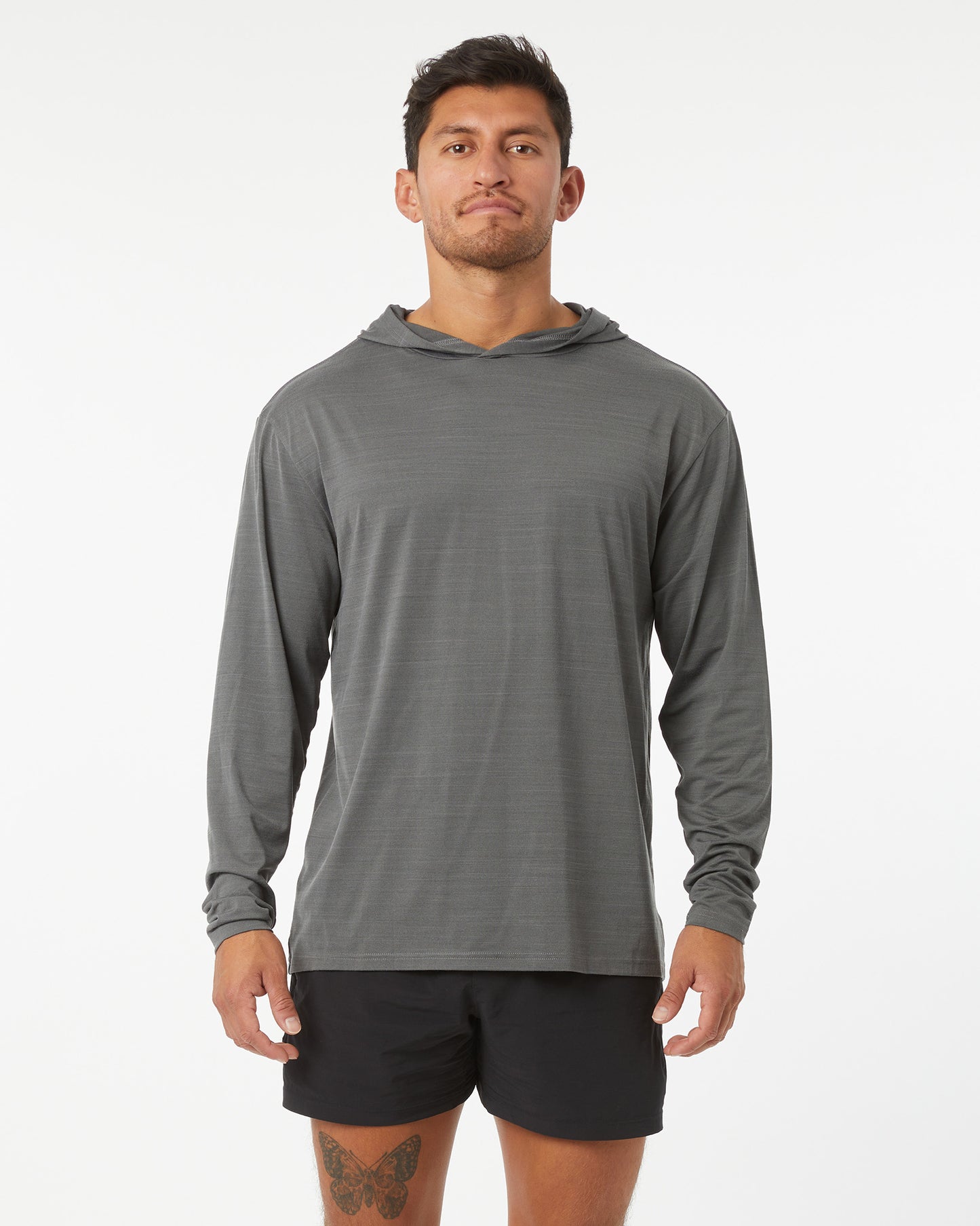 Man wearing a gray long-sleeve hoodie and black shorts on a white background