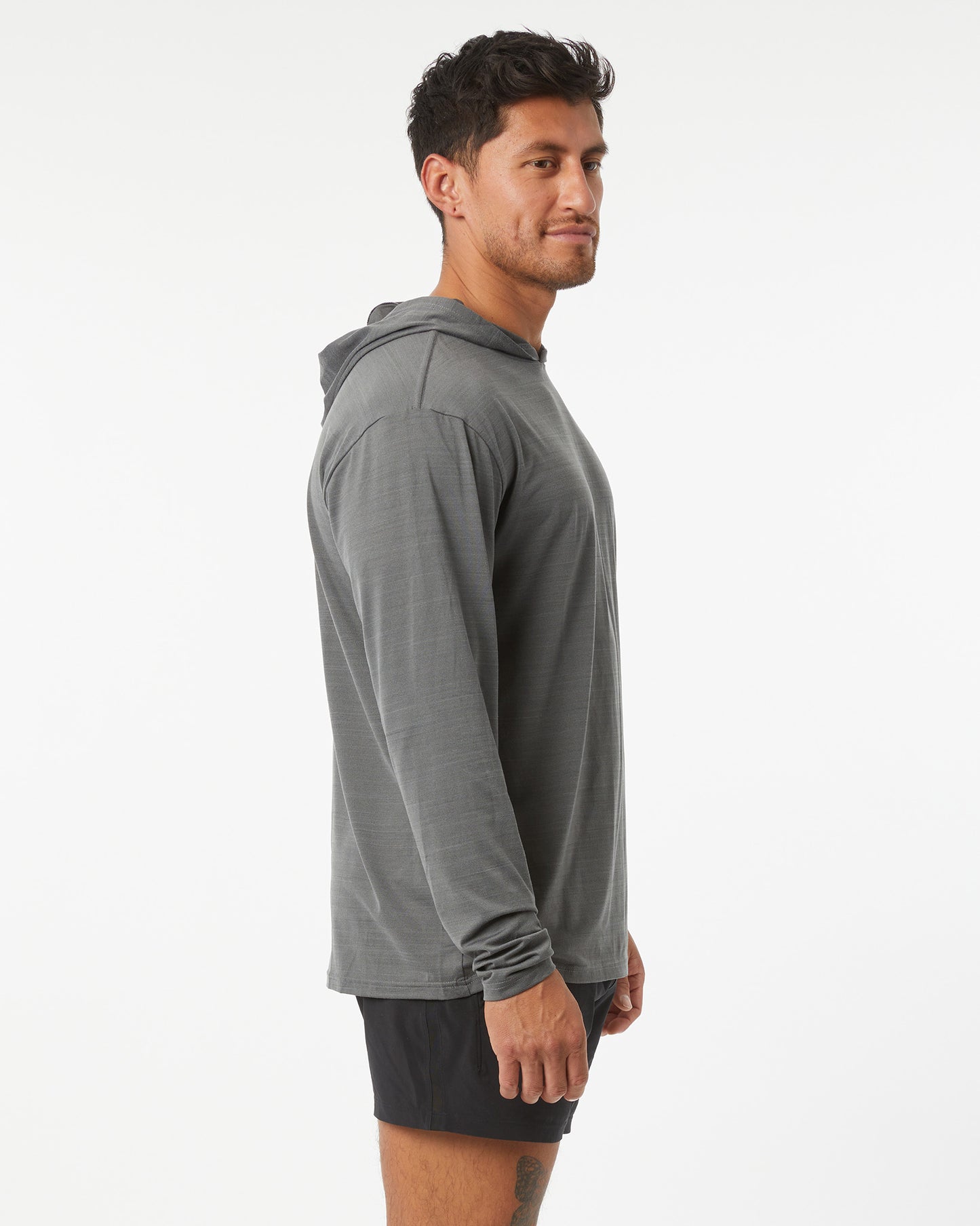 Man wearing a gray hoodie and black shorts on a white background