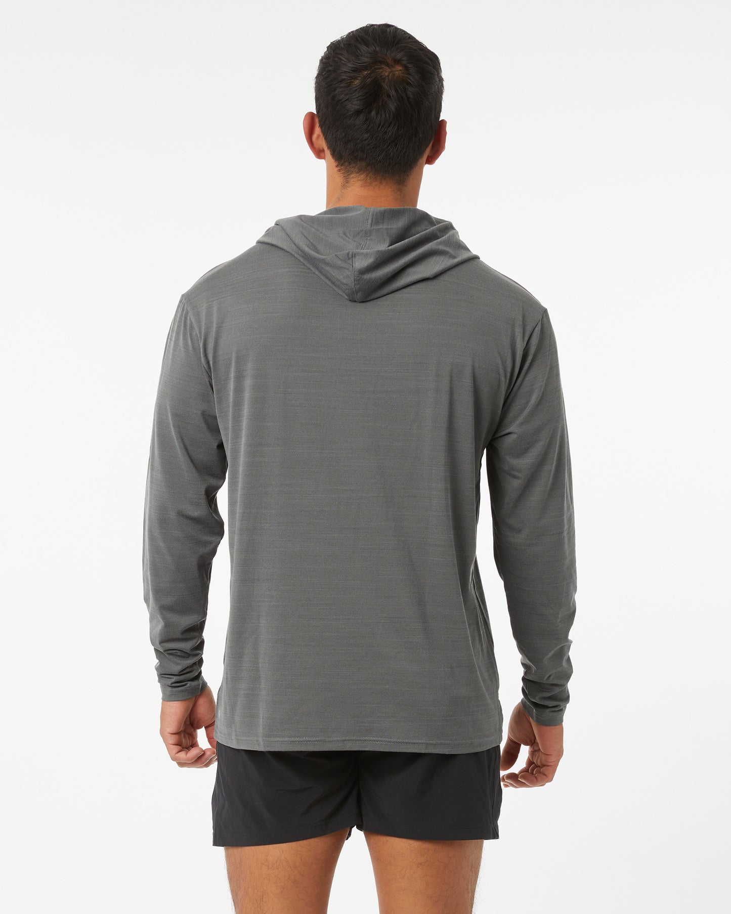 Person wearing a gray long-sleeve hoodie and black shorts on a white background