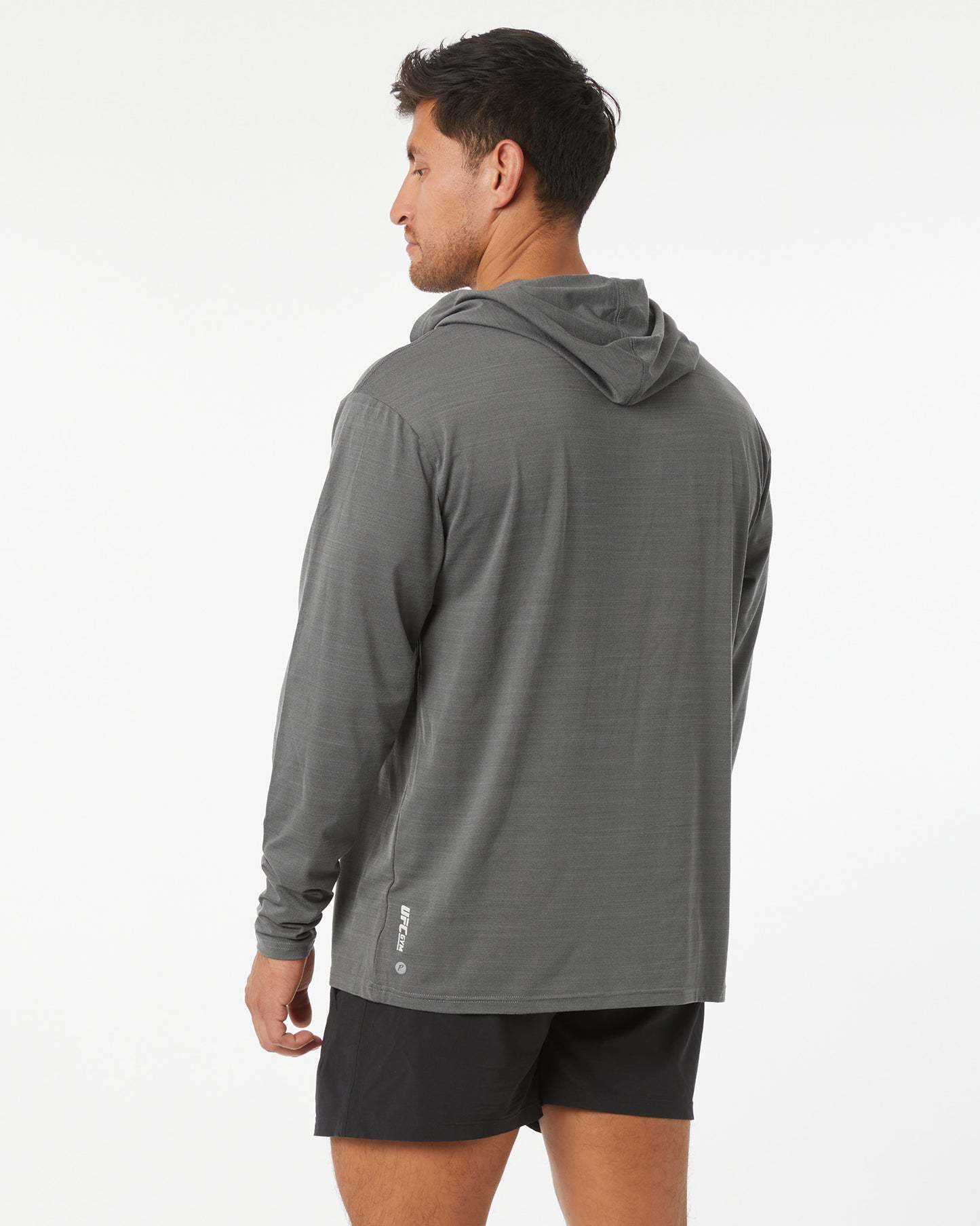 Man wearing a gray hoodie and black shorts on a white background