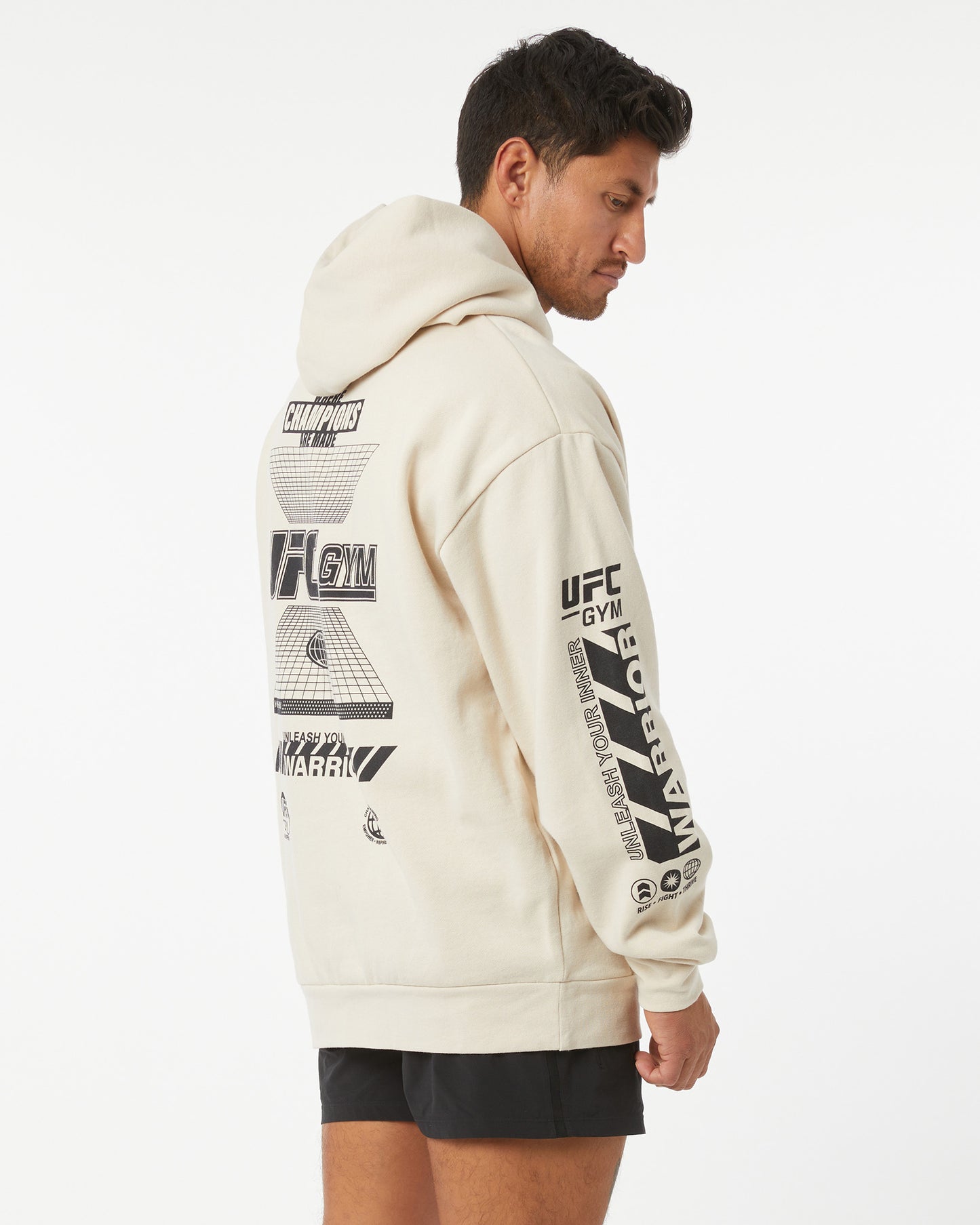 Person wearing a beige hoodie with UFC Gym branding on a white background