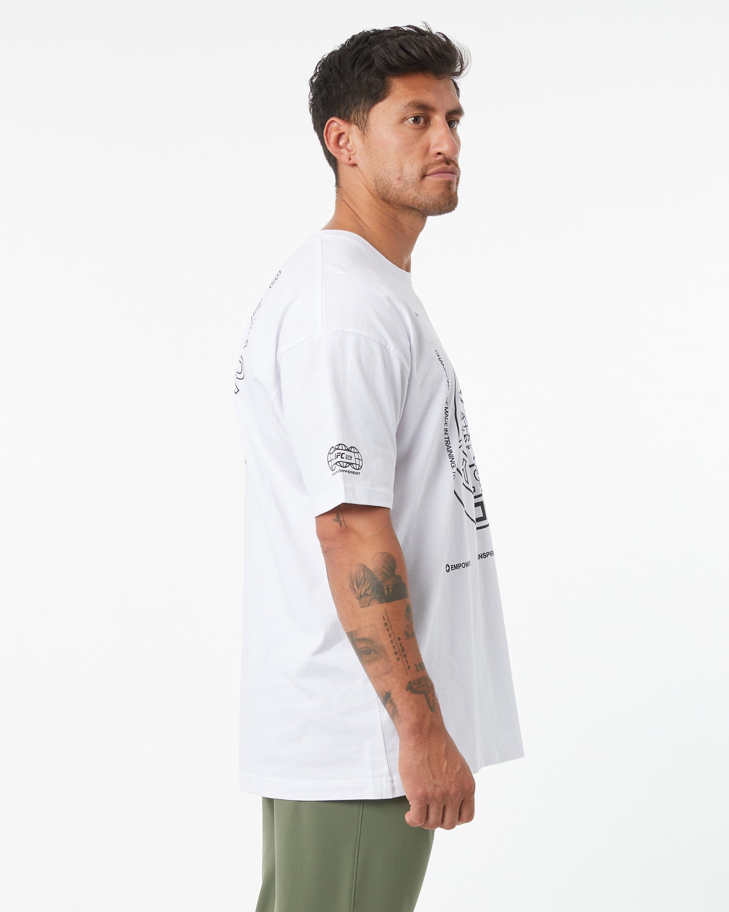 Man wearing a white t-shirt with text and graphics on a plain background