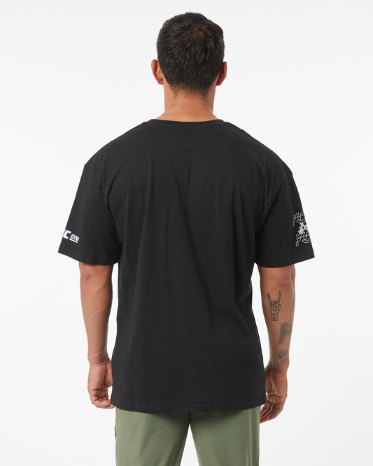 Man wearing a black t-shirt with logos on the back and sleeves, standing against a white background.