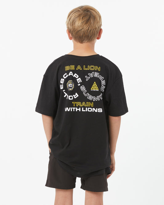 Child wearing a black t-shirt with text and logos on the back, standing against a white background