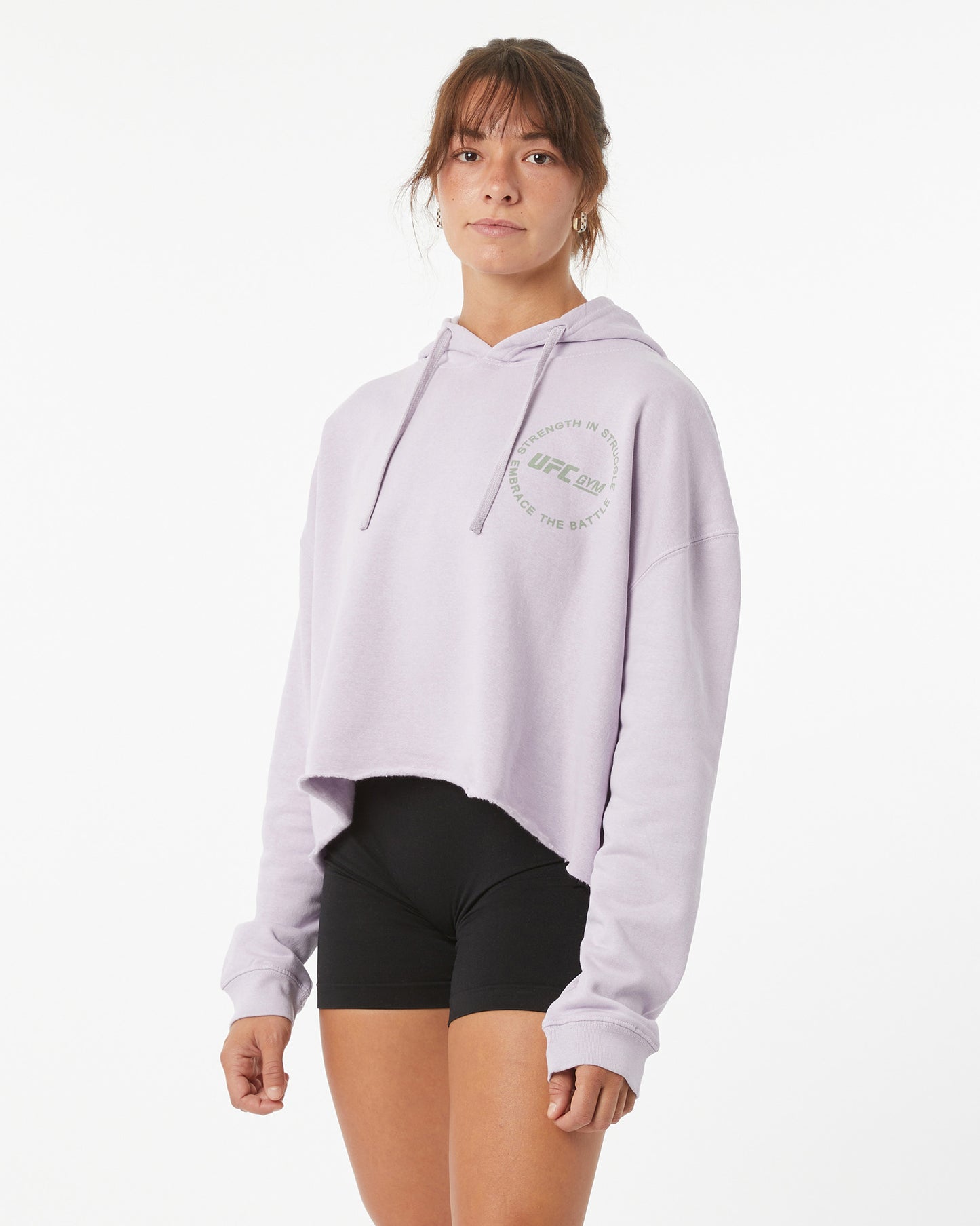 Woman in a crop top hoodie with a UFC GYM logo on the front