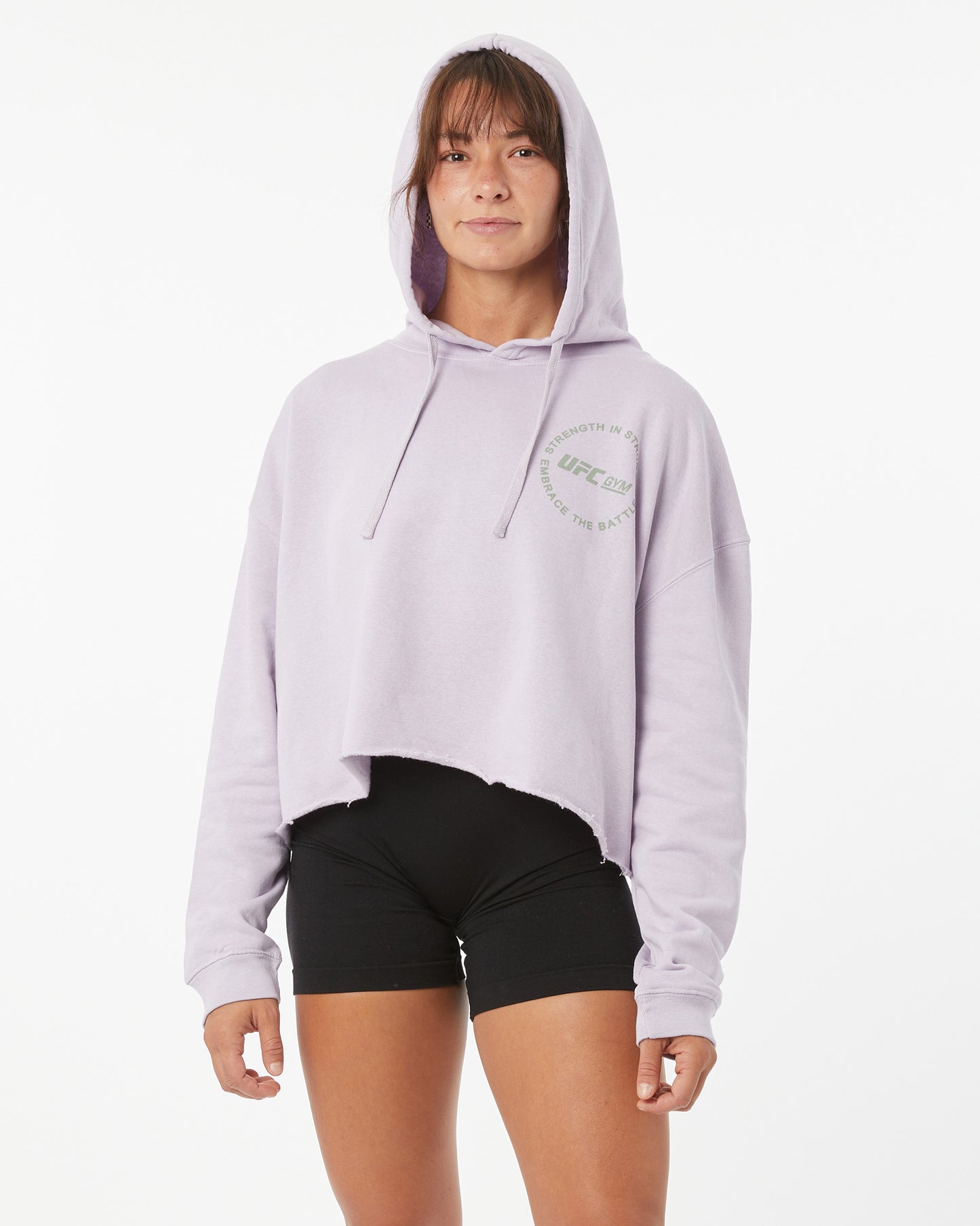 Person wearing a light purple hoodie with a logo on a white background