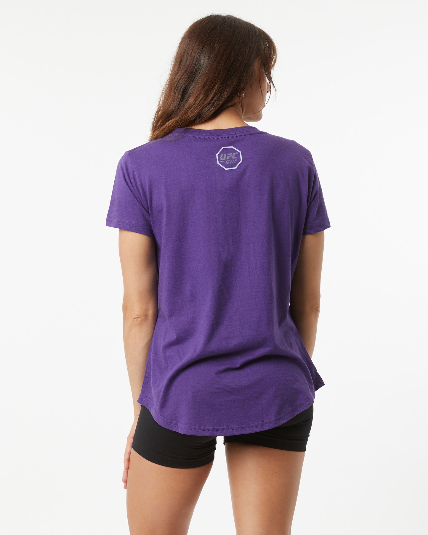 Person wearing a purple t-shirt with a logo on the back against a white background