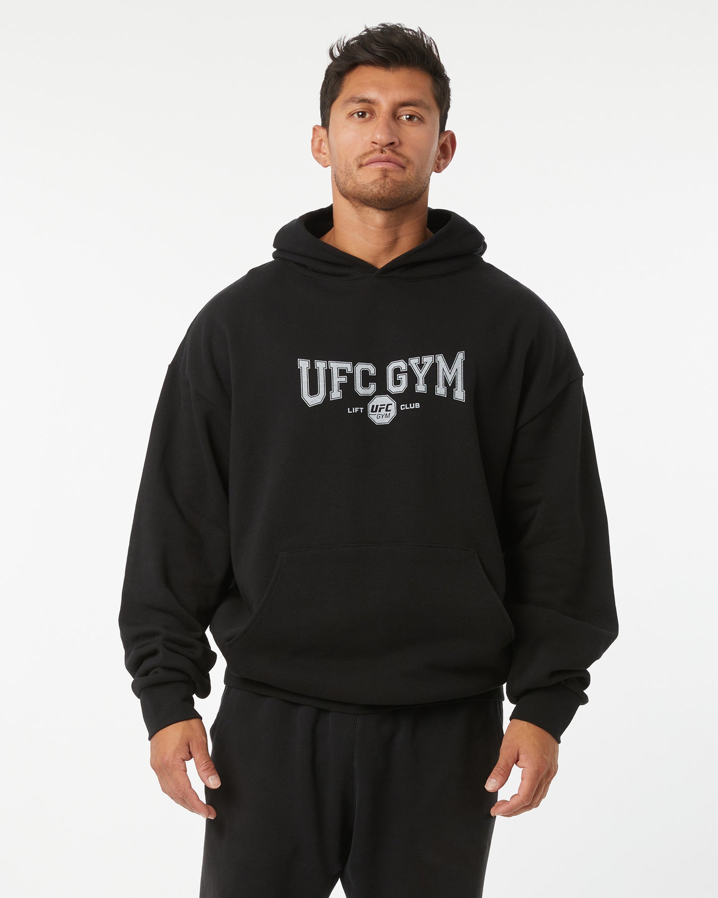Man wearing a black hoodie with 'UFC GYM' and 'LIFT CLUB' text on a white background