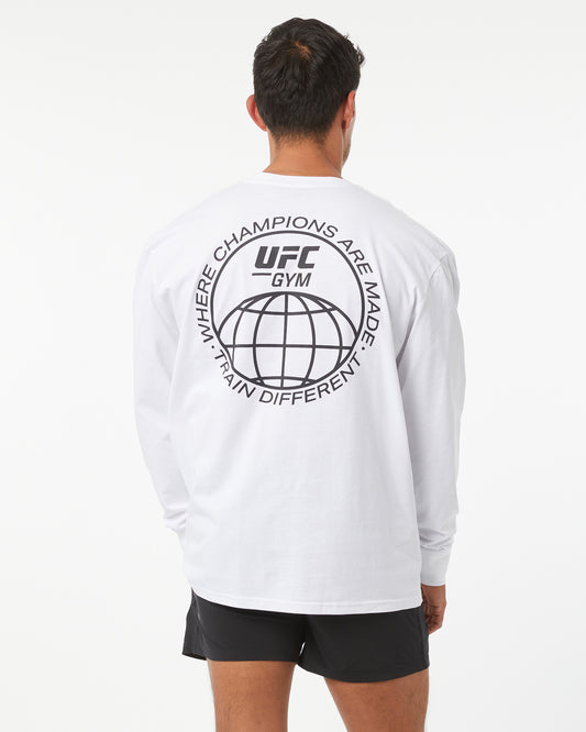 Person wearing a white UFC Gym long-sleeve shirt with a logo on the back.
