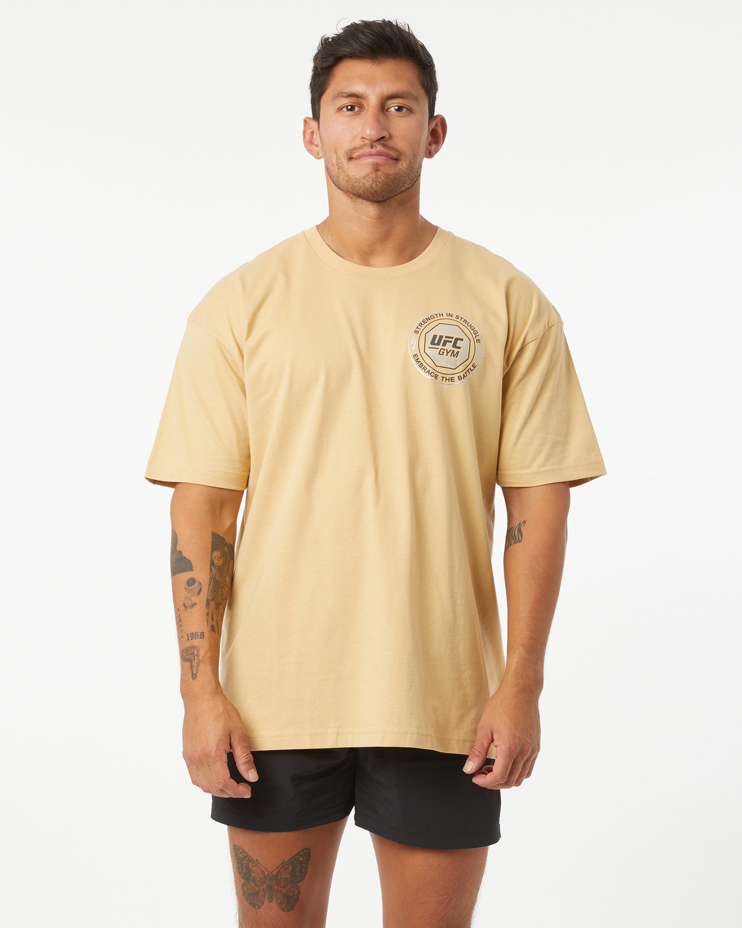 Man wearing a beige UFC t-shirt on a white background