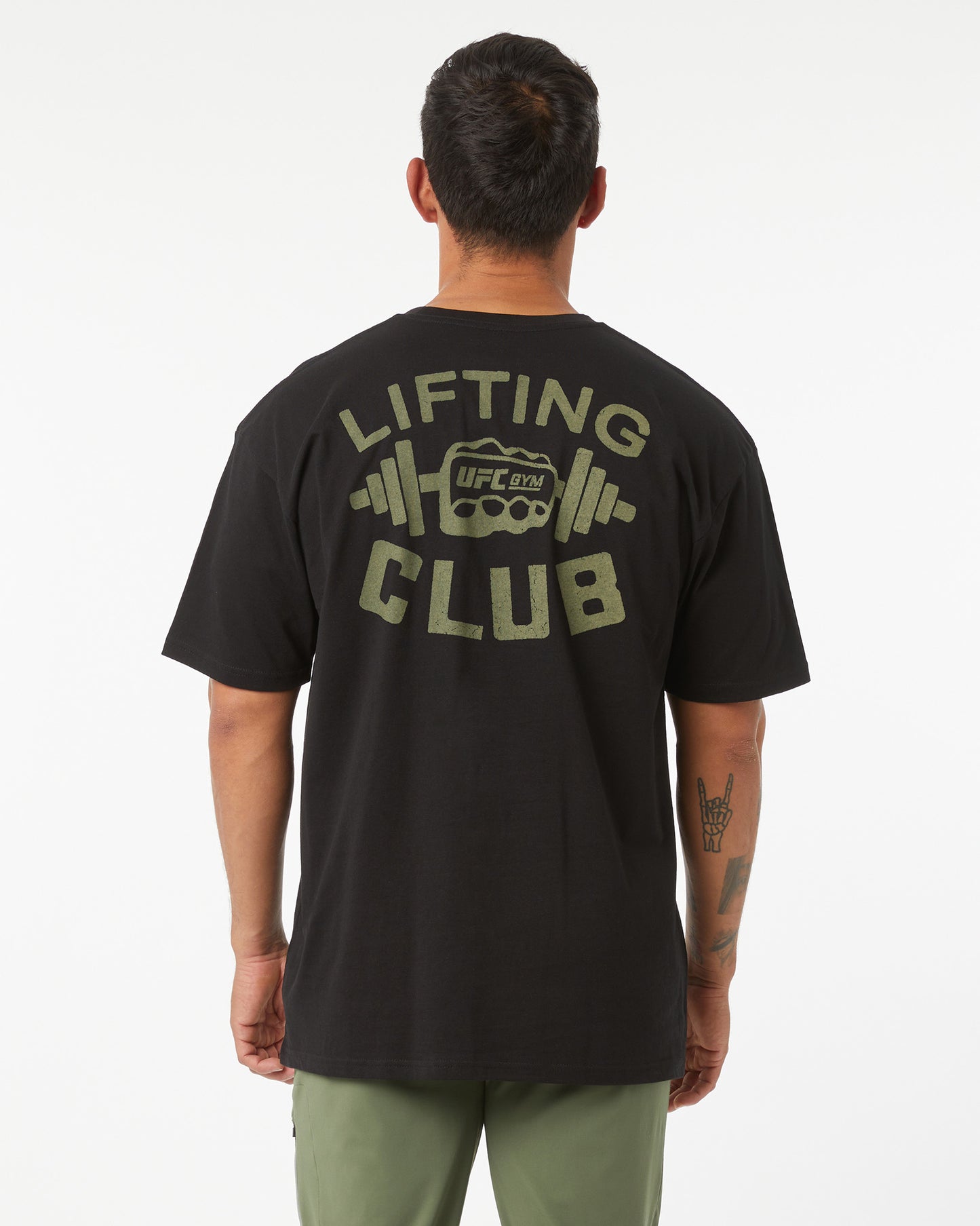 Person wearing a black t-shirt with 'Lifting Club' text and logo on the back, standing against a white background.