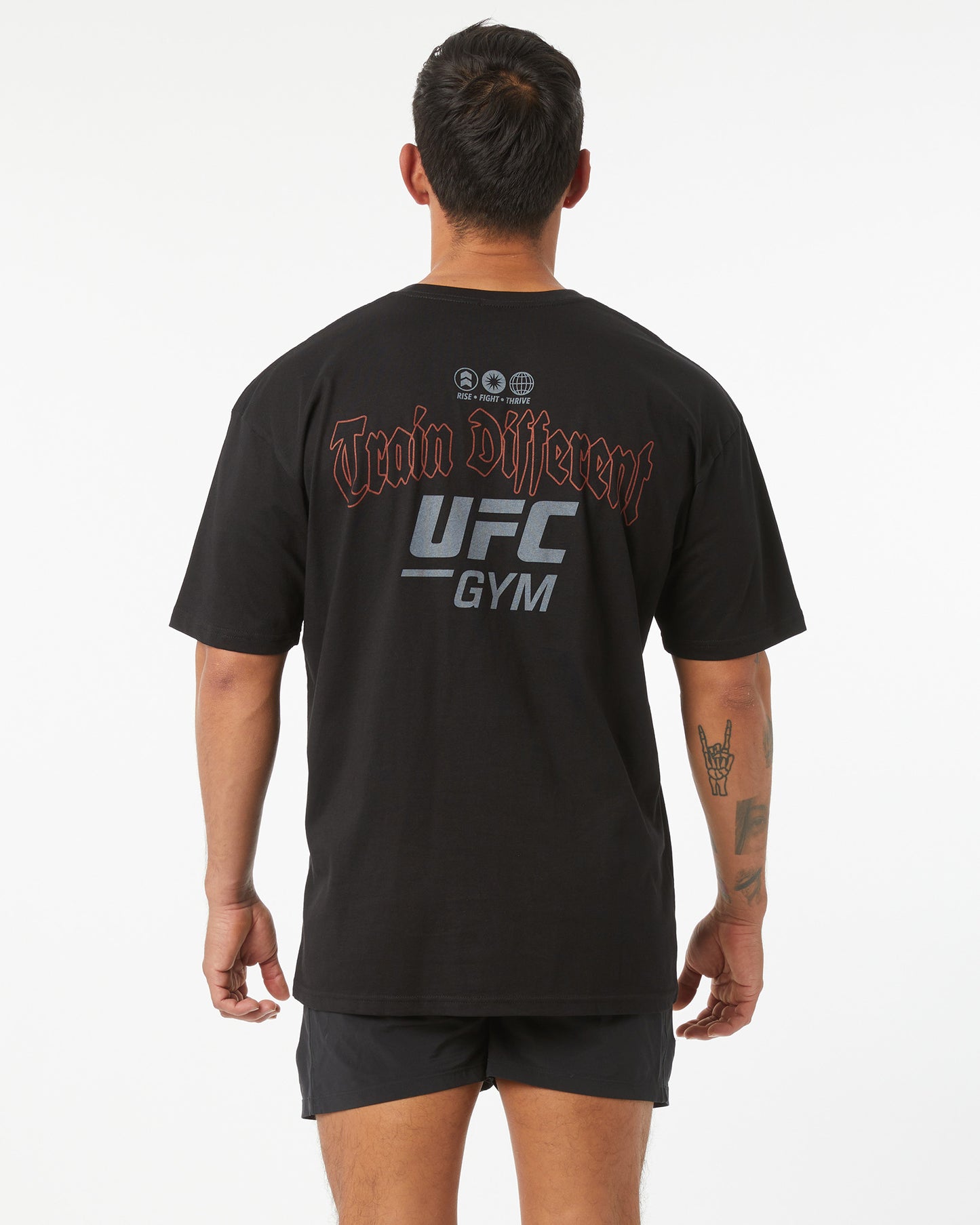 Person wearing a black UFC Gym t-shirt with branding on the back.
