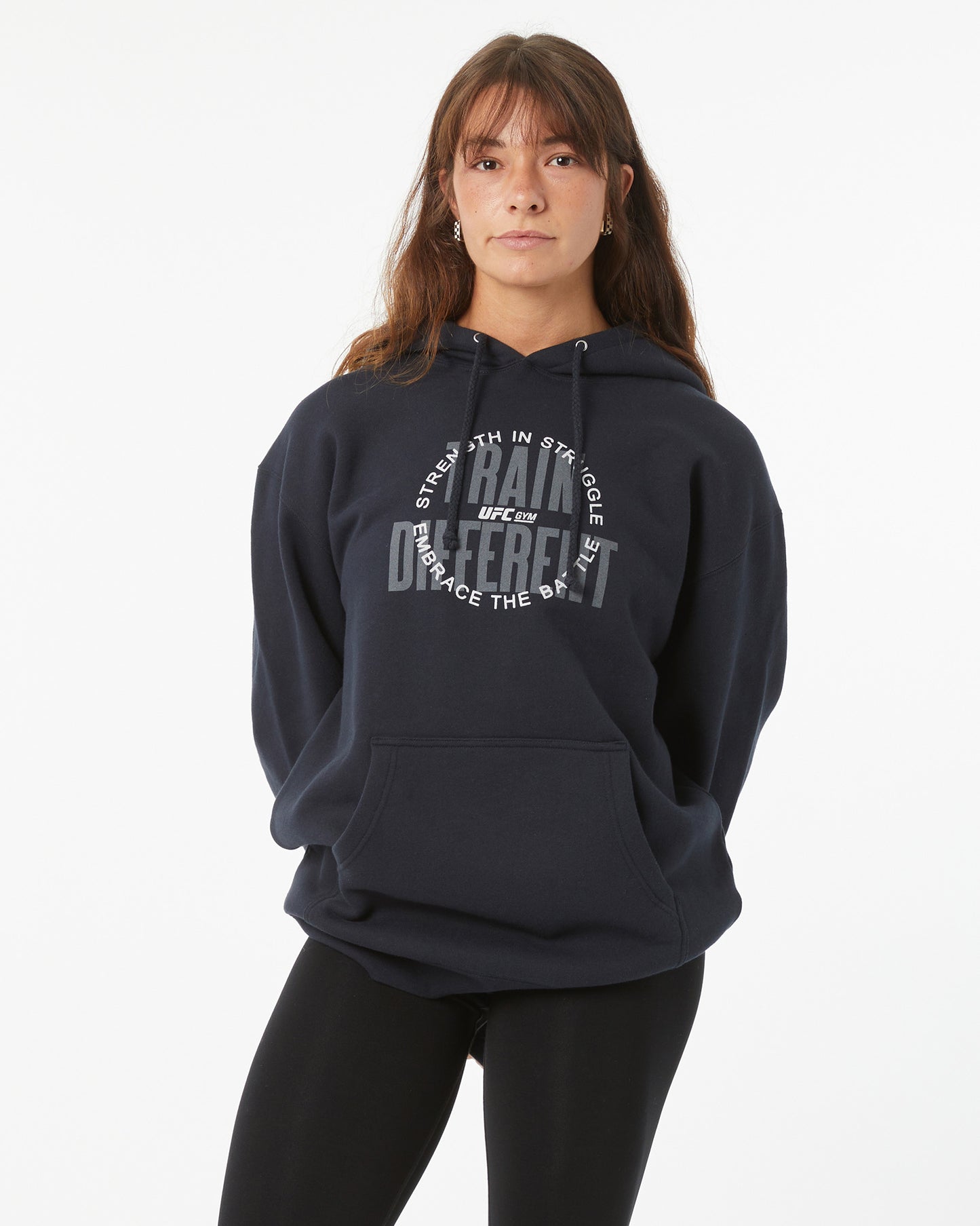 Person wearing a navy hoodie with text on a white background with their hands behind their back