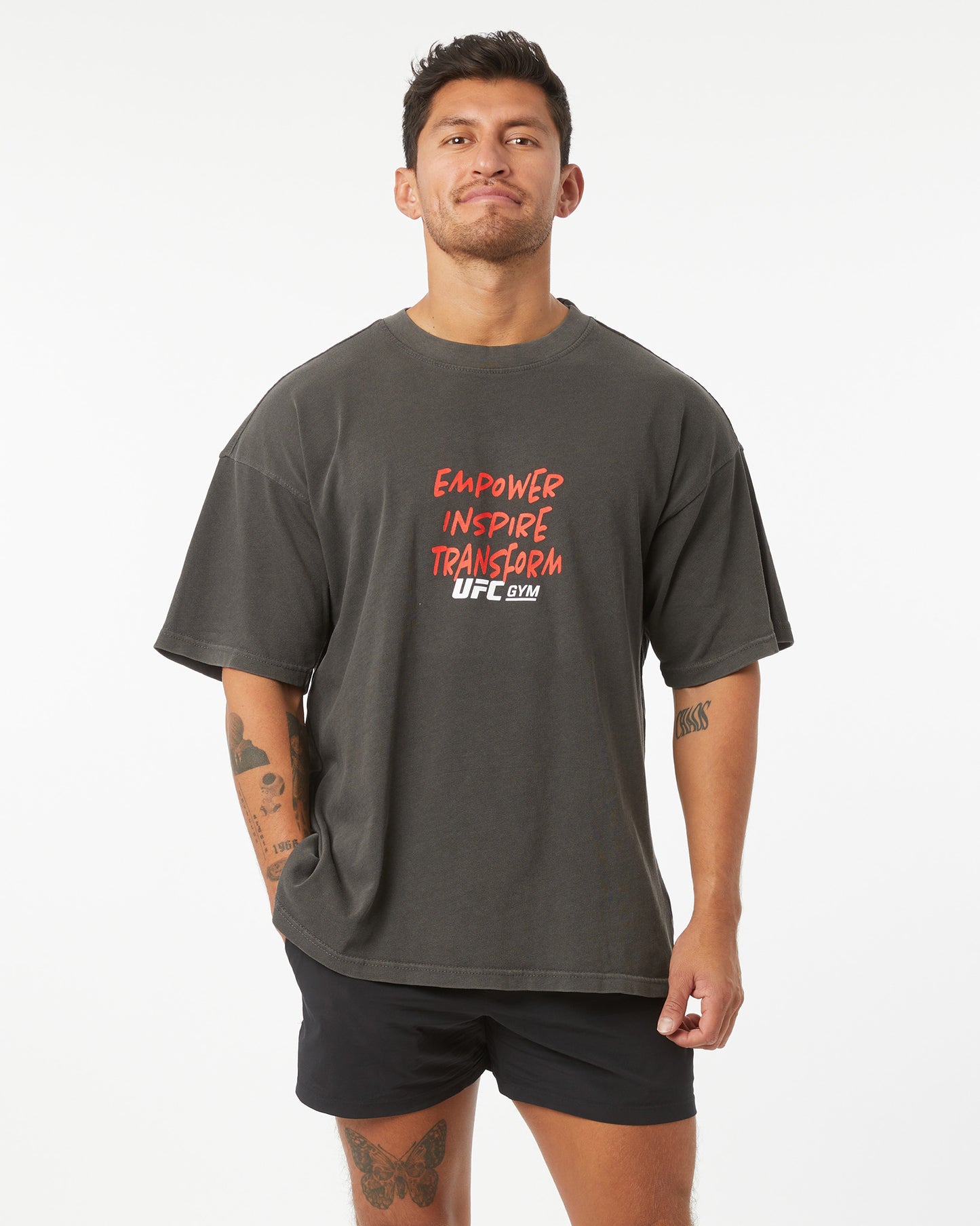 Man wearing a dark gray t-shirt with red and white text on a white background