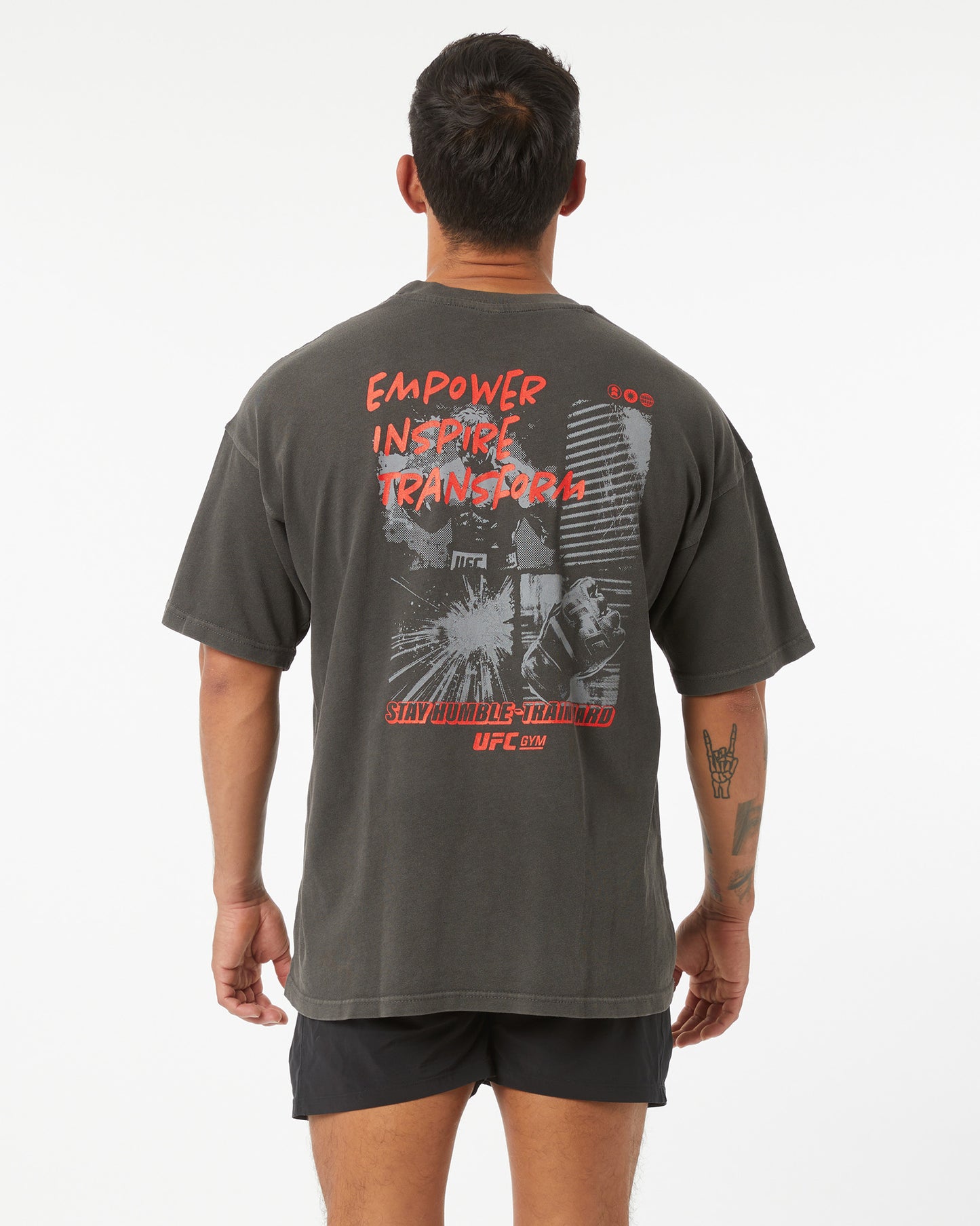 Person wearing a gray t-shirt with text and graphics on the back, on a white background