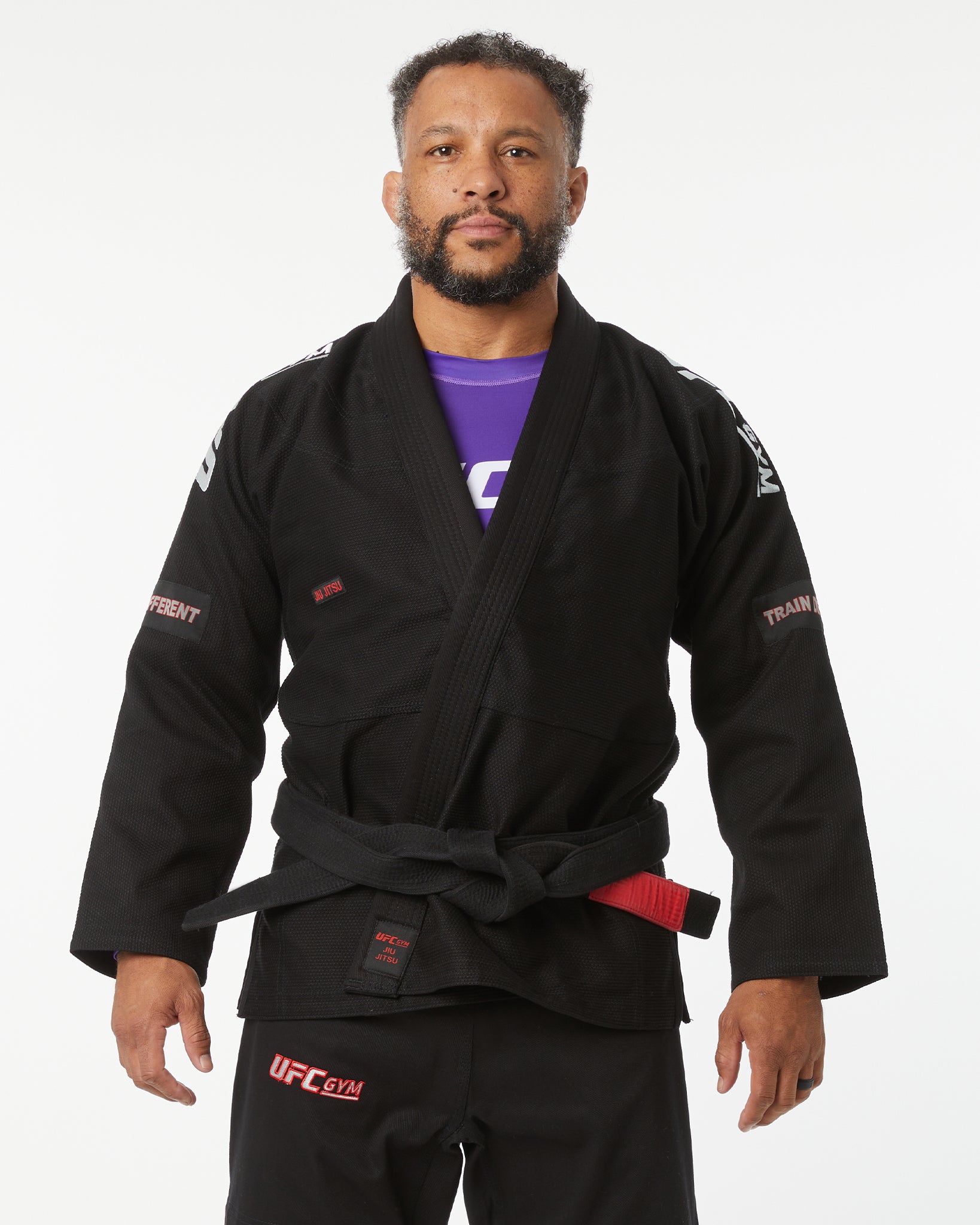 Man wearing a black UFC gym gi on a white background hands down