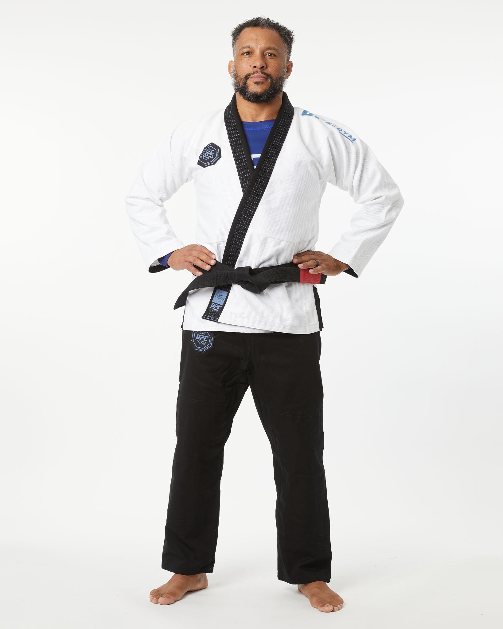 Man wearing a white martial arts uniform with a black belt on a white background