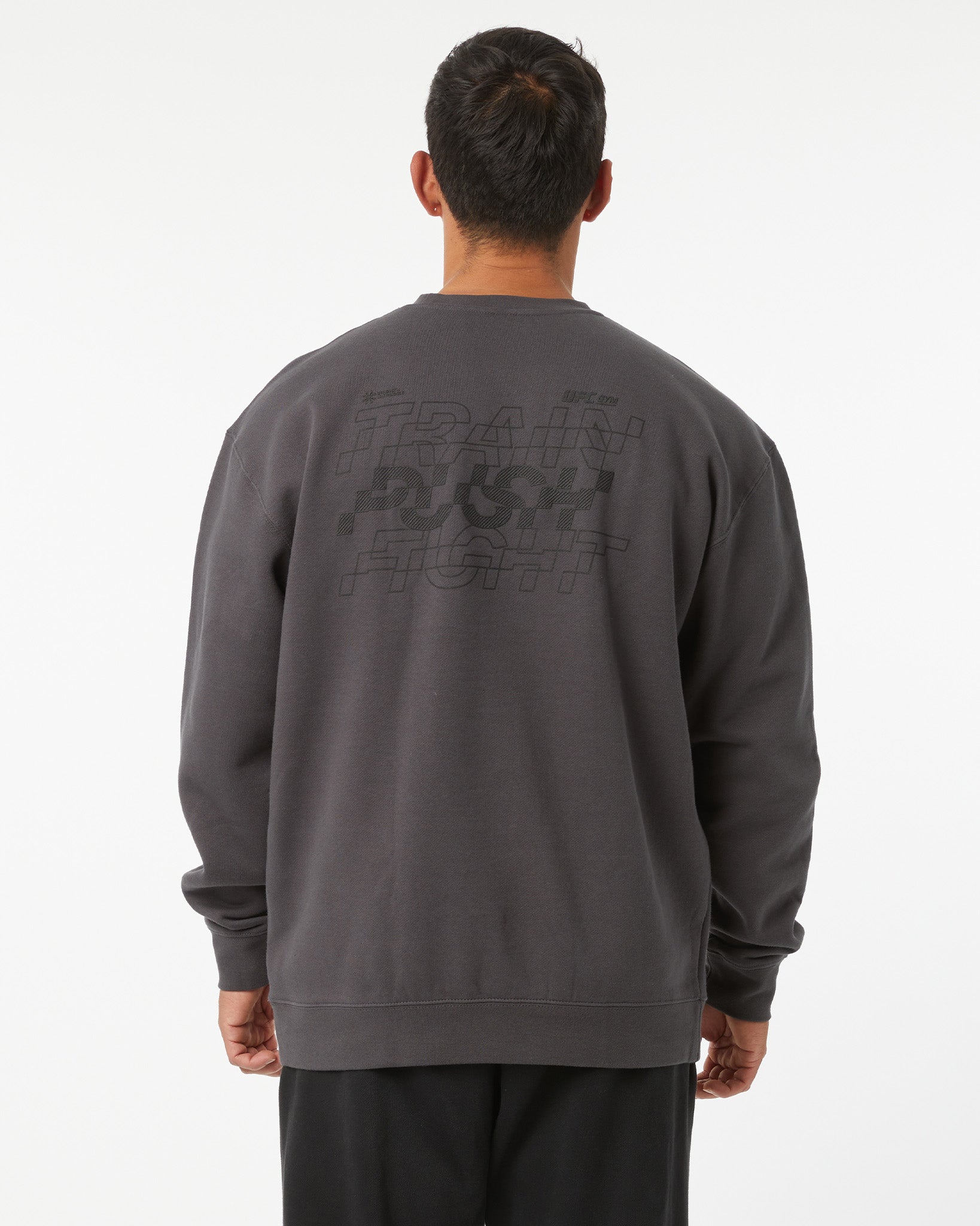 Person wearing a dark gray sweatshirt with text on the back against a white background