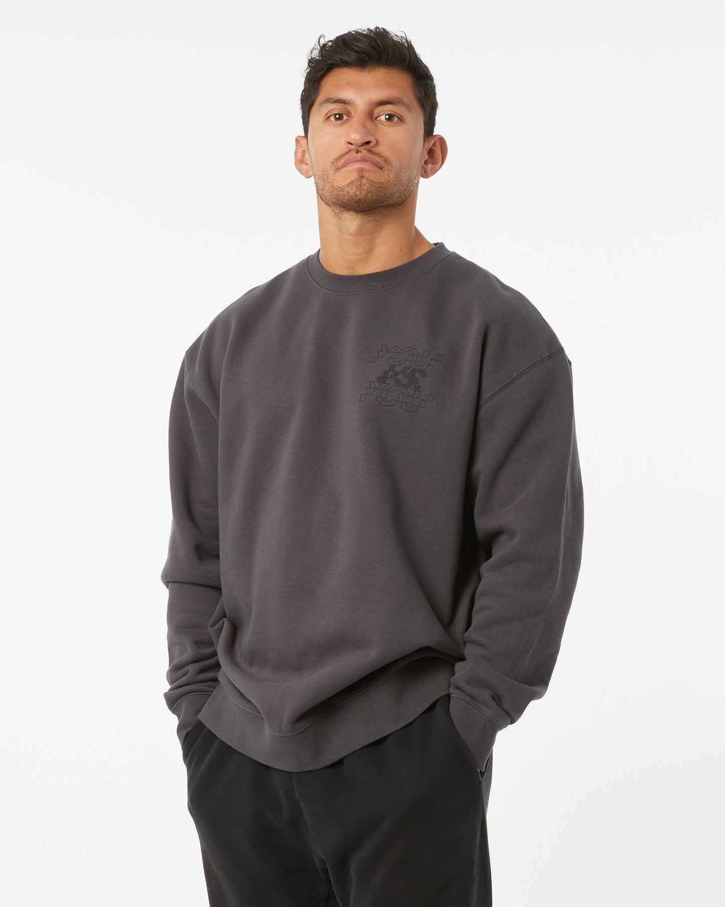 Man wearing a dark gray sweatshirt with a logo on a white background