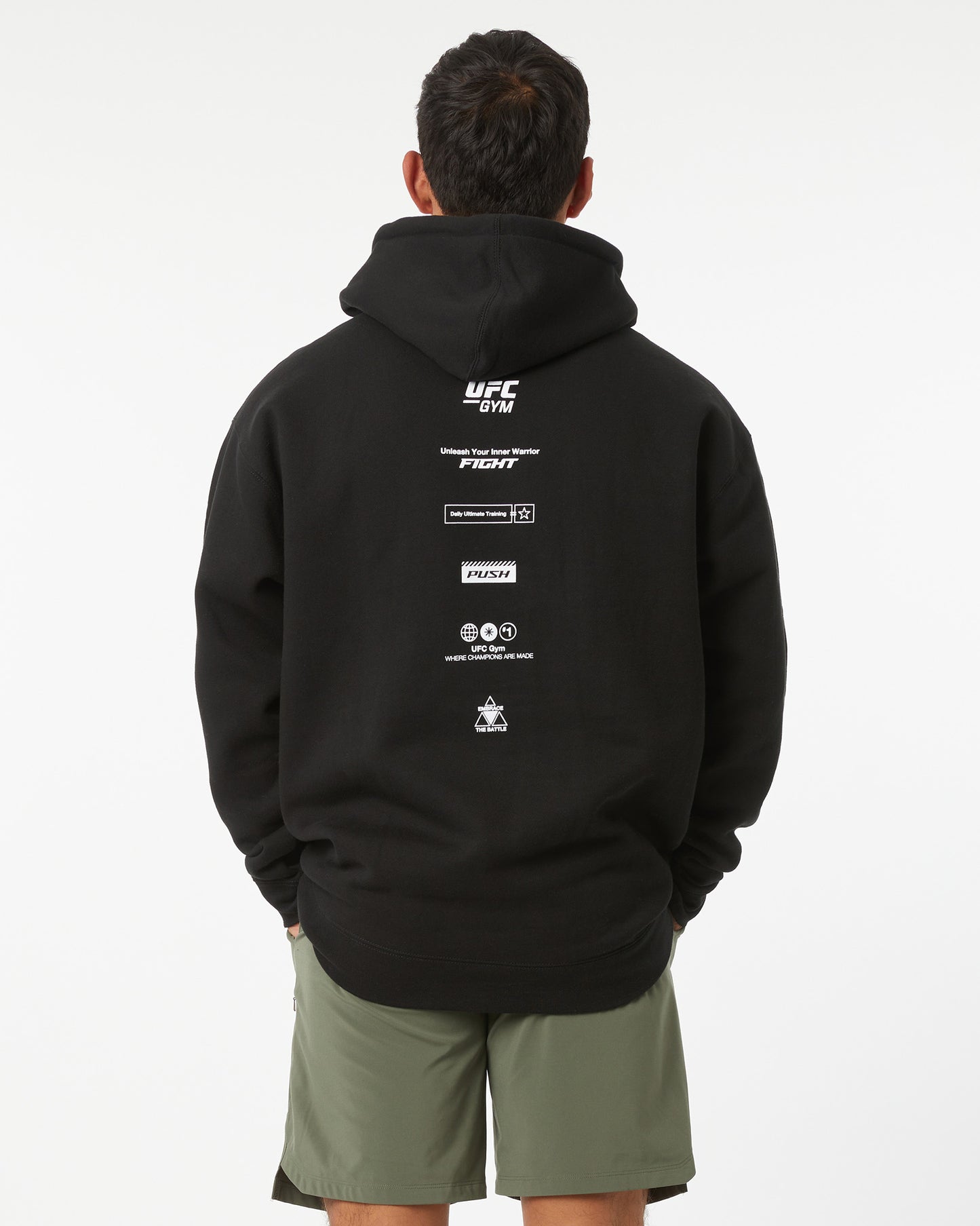 Person wearing a black hoodie with UFC branding on the back against a white background