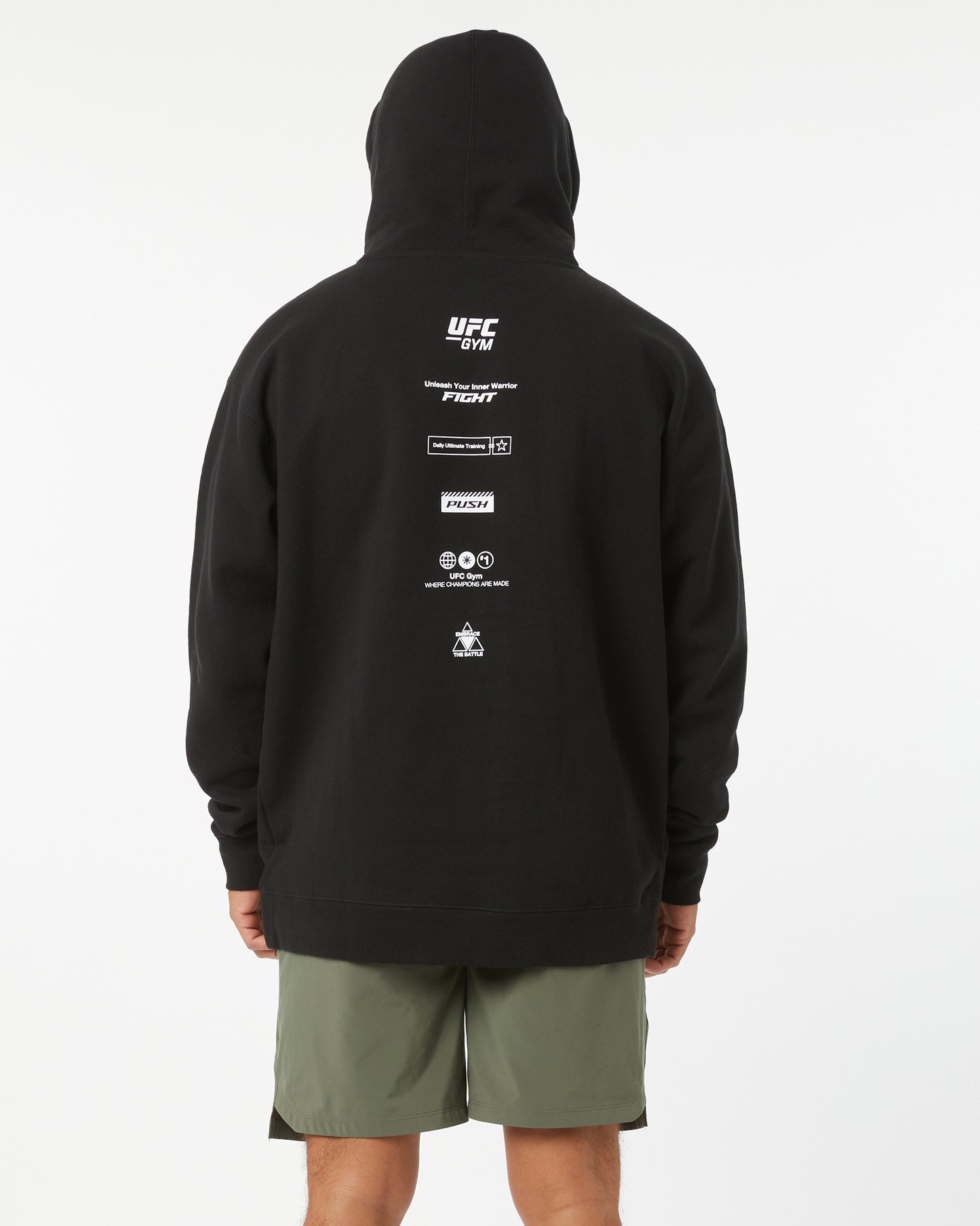 Person wearing a black hoodie with UFC branding on the back against a white background hood up