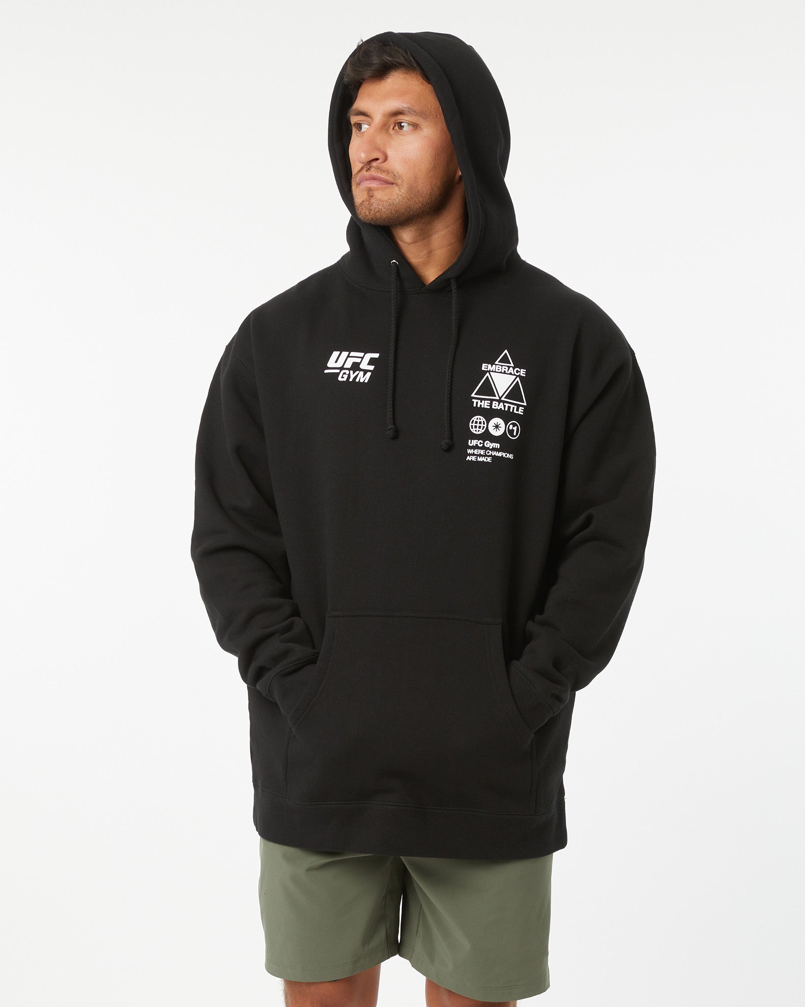 Person wearing a black UFC hoodie with branding on a white background hood up looking left