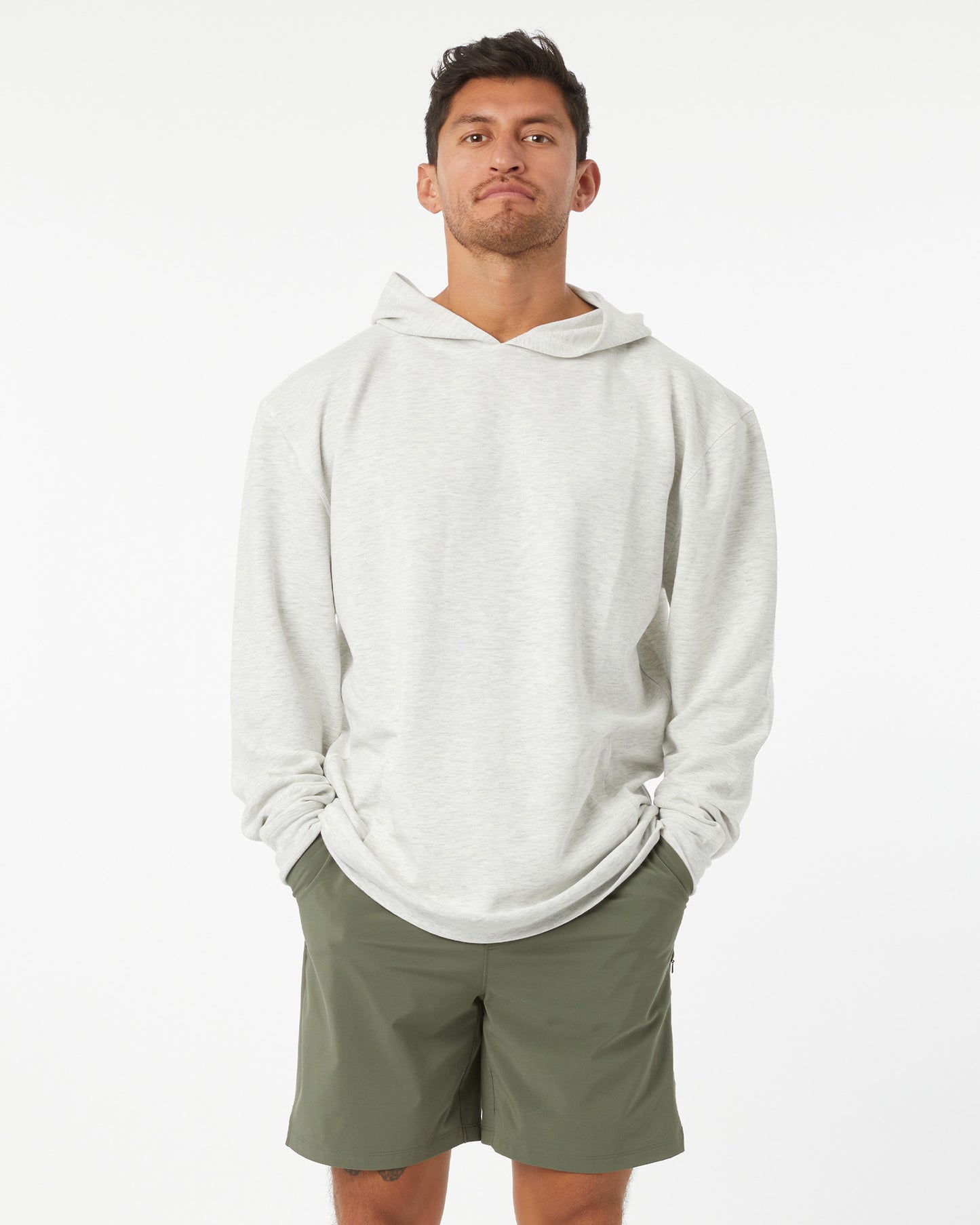 Man wearing a heather grey hoodie and green shorts on a white background