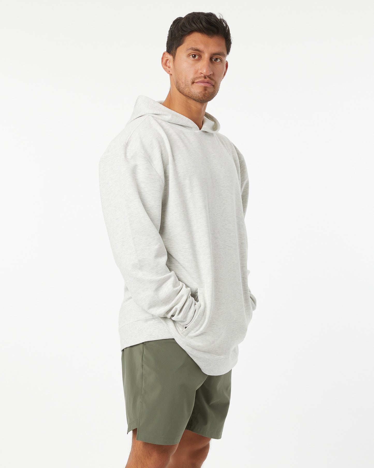 Man wearing a heather grey hoodie and green shorts on a white background