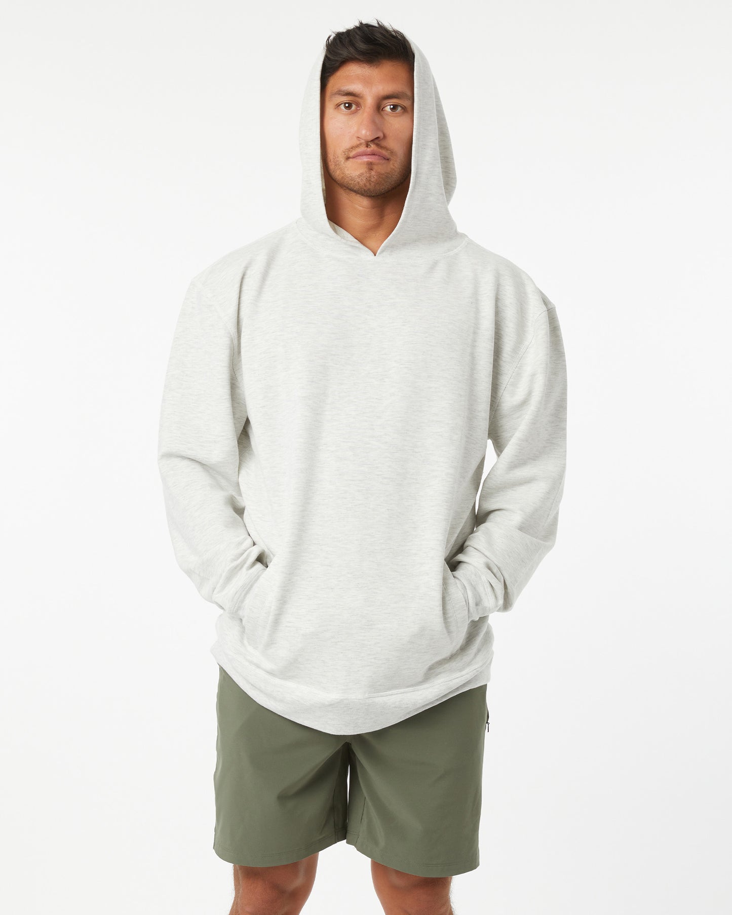 Man wearing a heather grey hoodie and green shorts on a white background