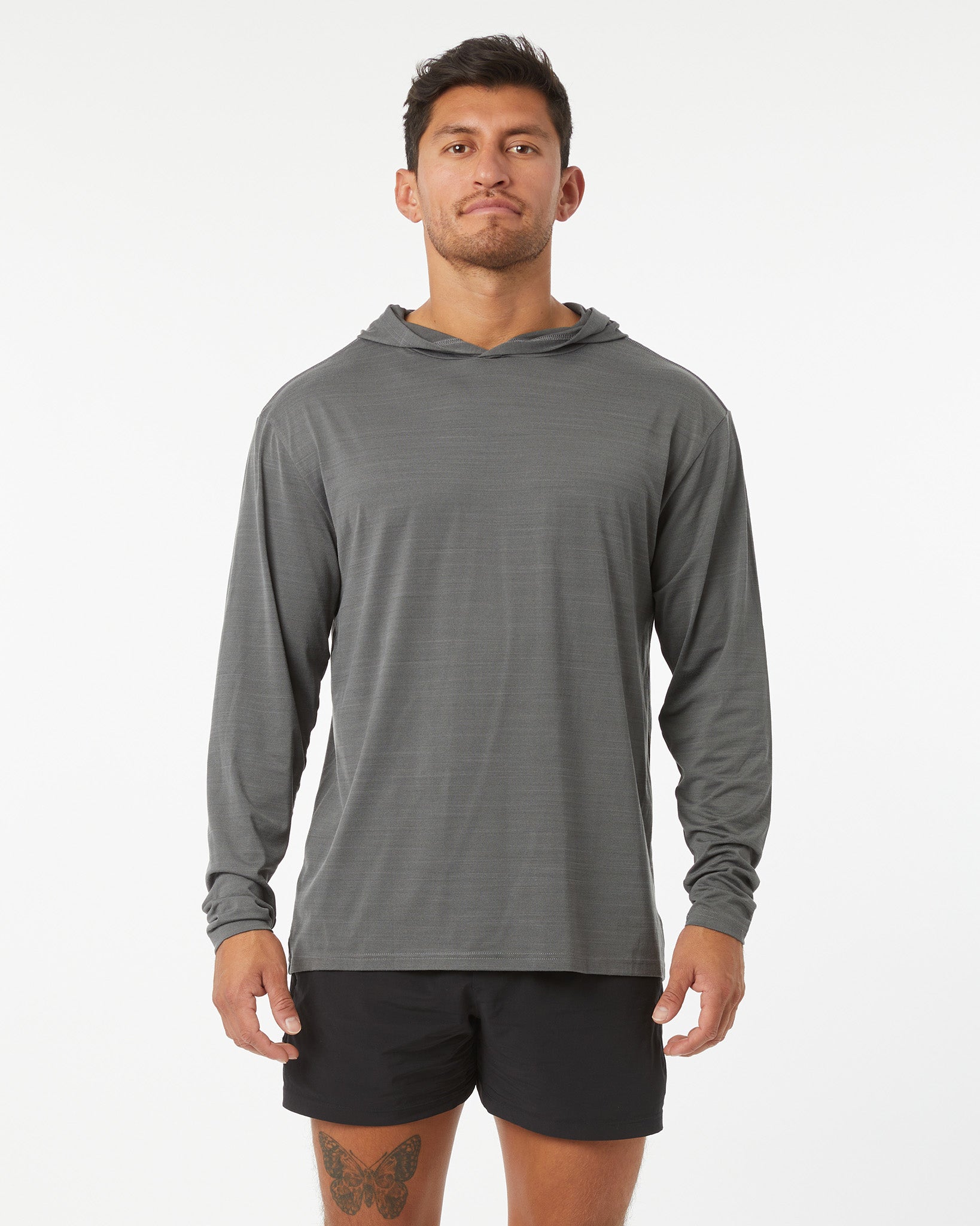 Man wearing a gray long-sleeve hoodie and black shorts on a white background