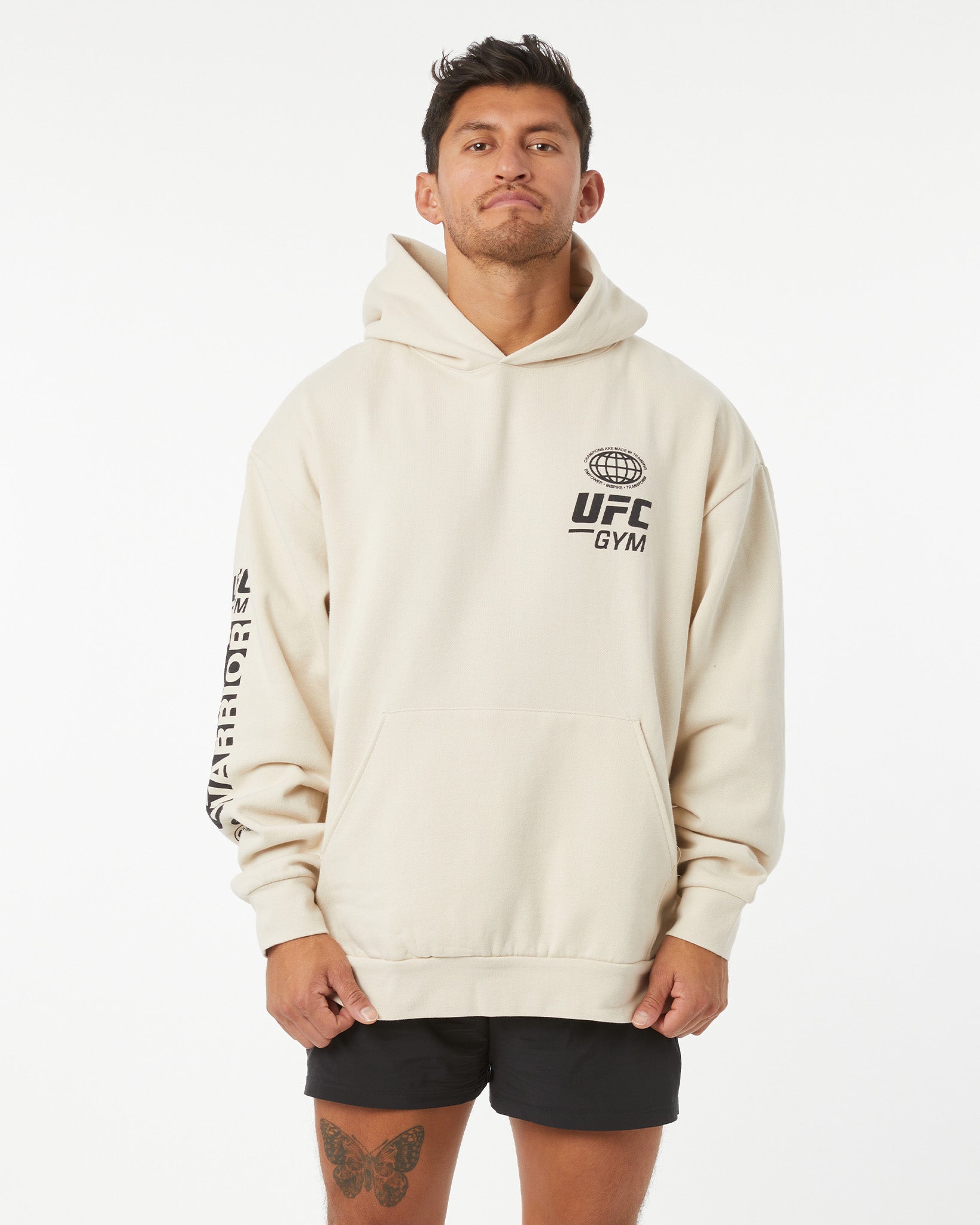 Man wearing a beige hoodie with UFC Gym logo on a white background