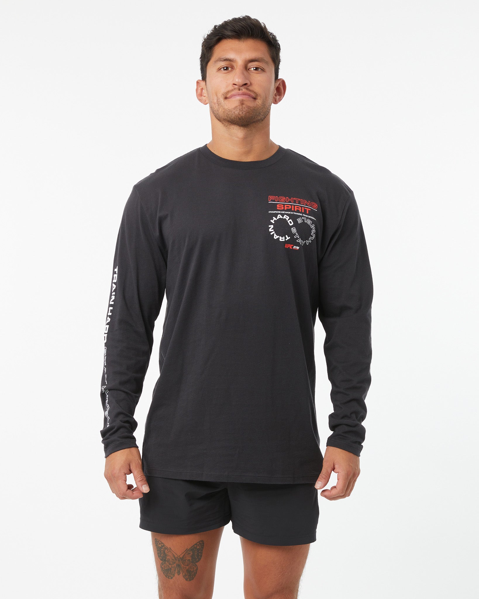 Man wearing a black long-sleeve shirt with a logo on a white background
