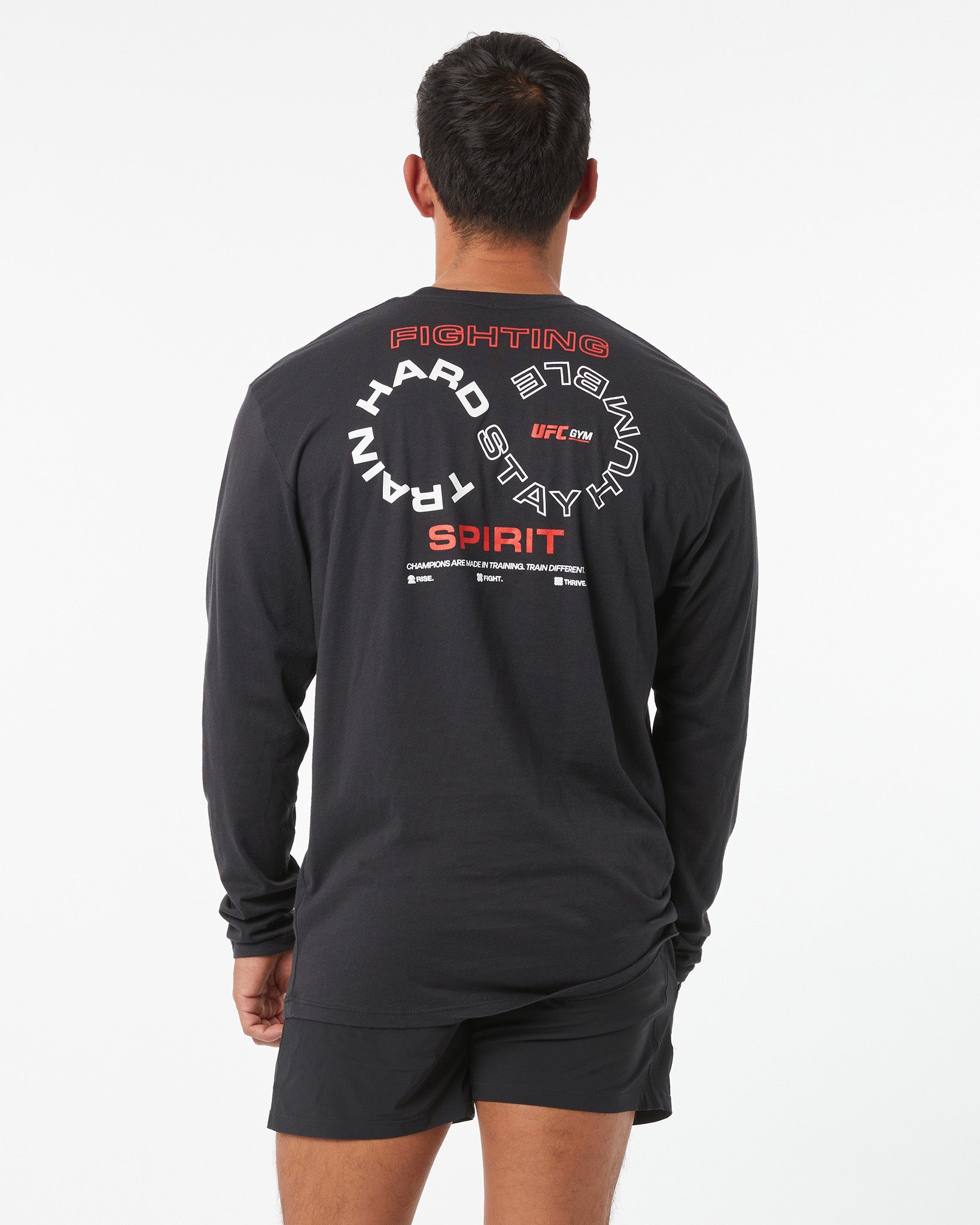 Person wearing a black long-sleeve shirt with UFC branding on the back against a white background