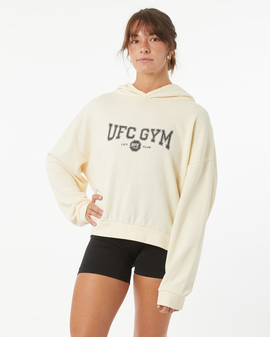 Woman wearing a bone white UFC Gym hoodie on a white background