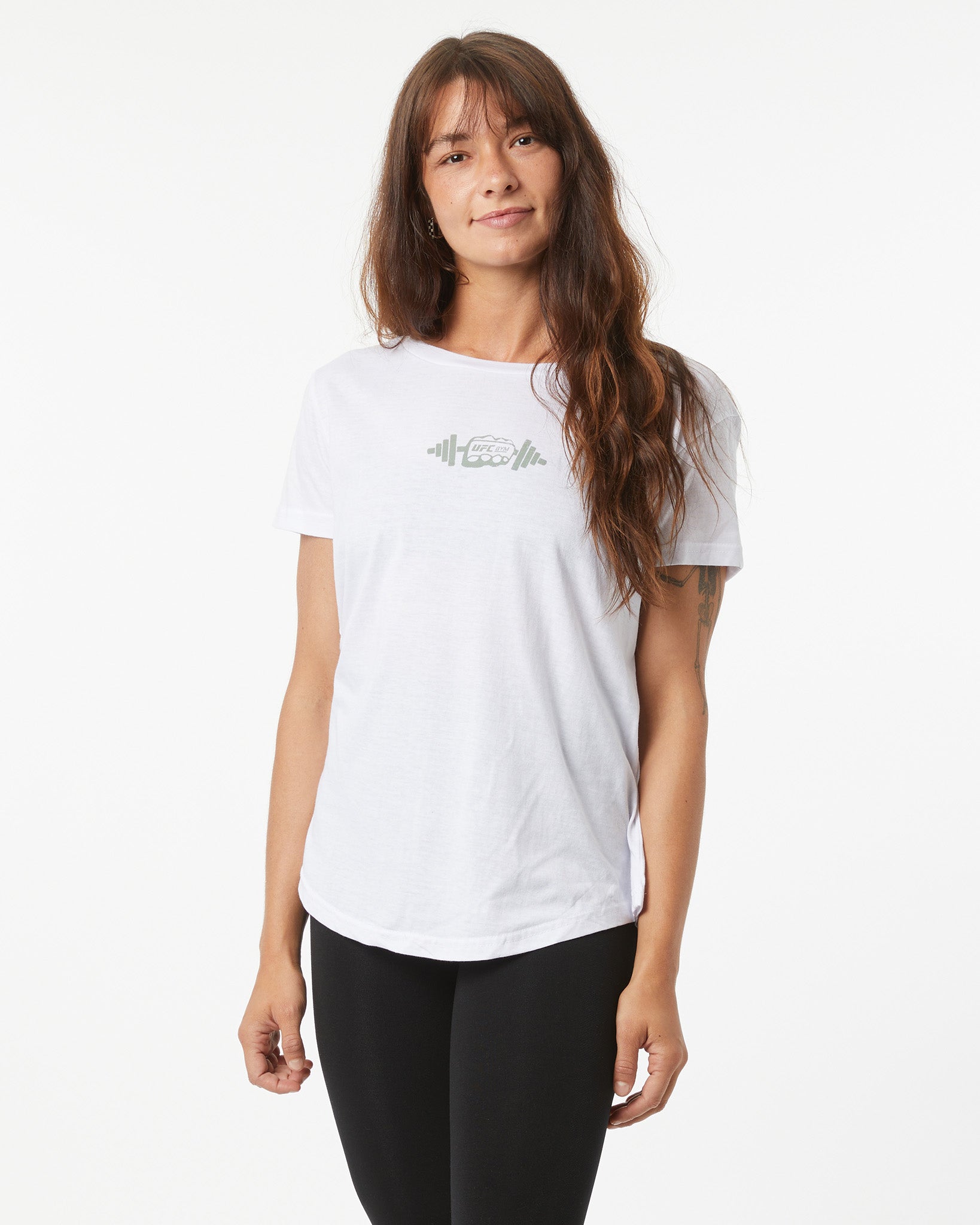 Woman wearing a white t-shirt with a logo on a plain background